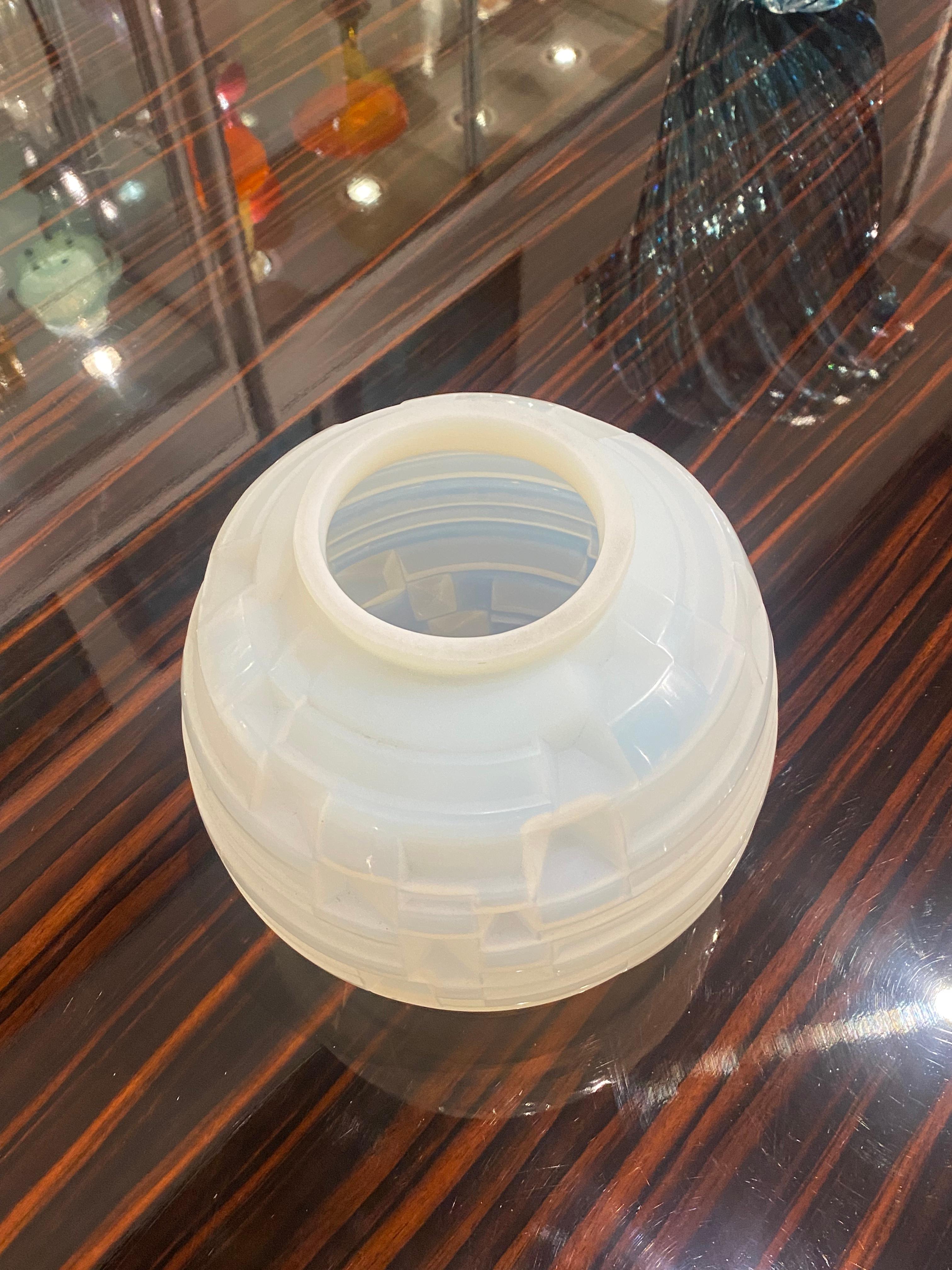 Art Déco-Vase aus mundgeblasenem Opalglas der Firma Hunebelle; runde Form mit einem Muster aus horizontalen Linien und eckigen Vertiefungen, das sich um das ganze Stück herum zieht.
Hergestellt in Frankreich.
Signatur: 