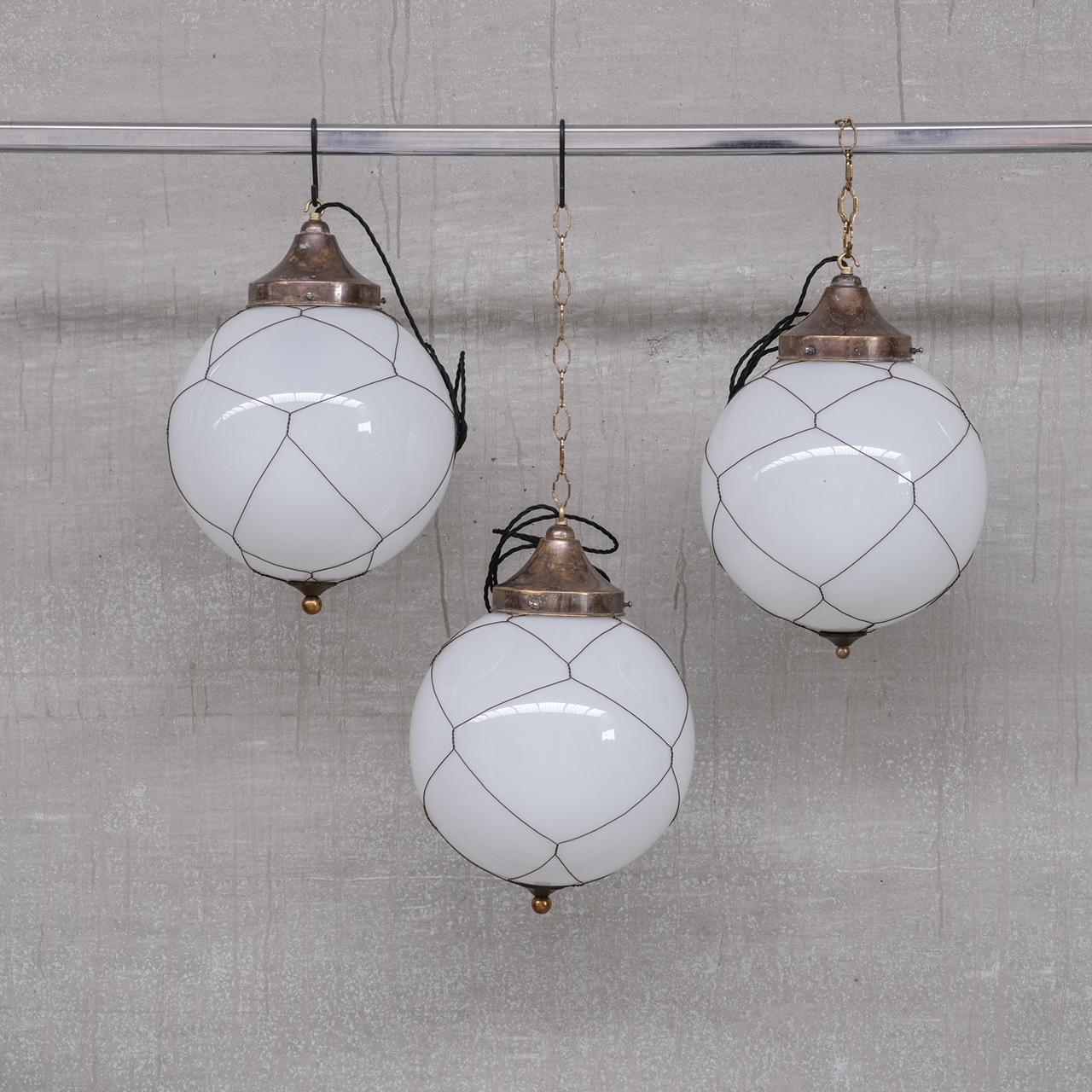 Opaline and brass caged glass pendant lights.

Holland, circa 1950s.

Natural patina to the metal.

PRICED AND SOLD INDIVIDUALLY.

3 available at the time of listing. Please check for updated stock amounts.

Re-wired and PAT