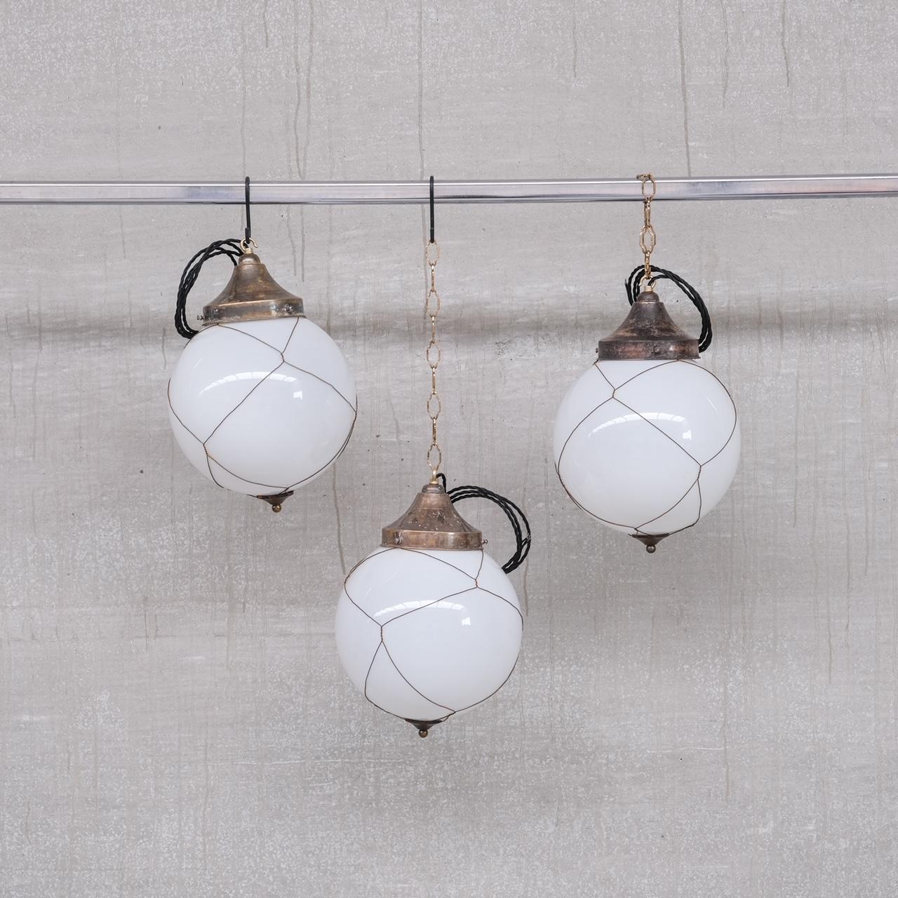 Opaline and brass caged glass pendant lights.

Holland, circa 1950s.

Natural patina to the metal.

PRICED AND SOLD INDIVIDUALLY.

7 available at the time of listing. Please check for updated stock amounts.

Re-wired and PAT