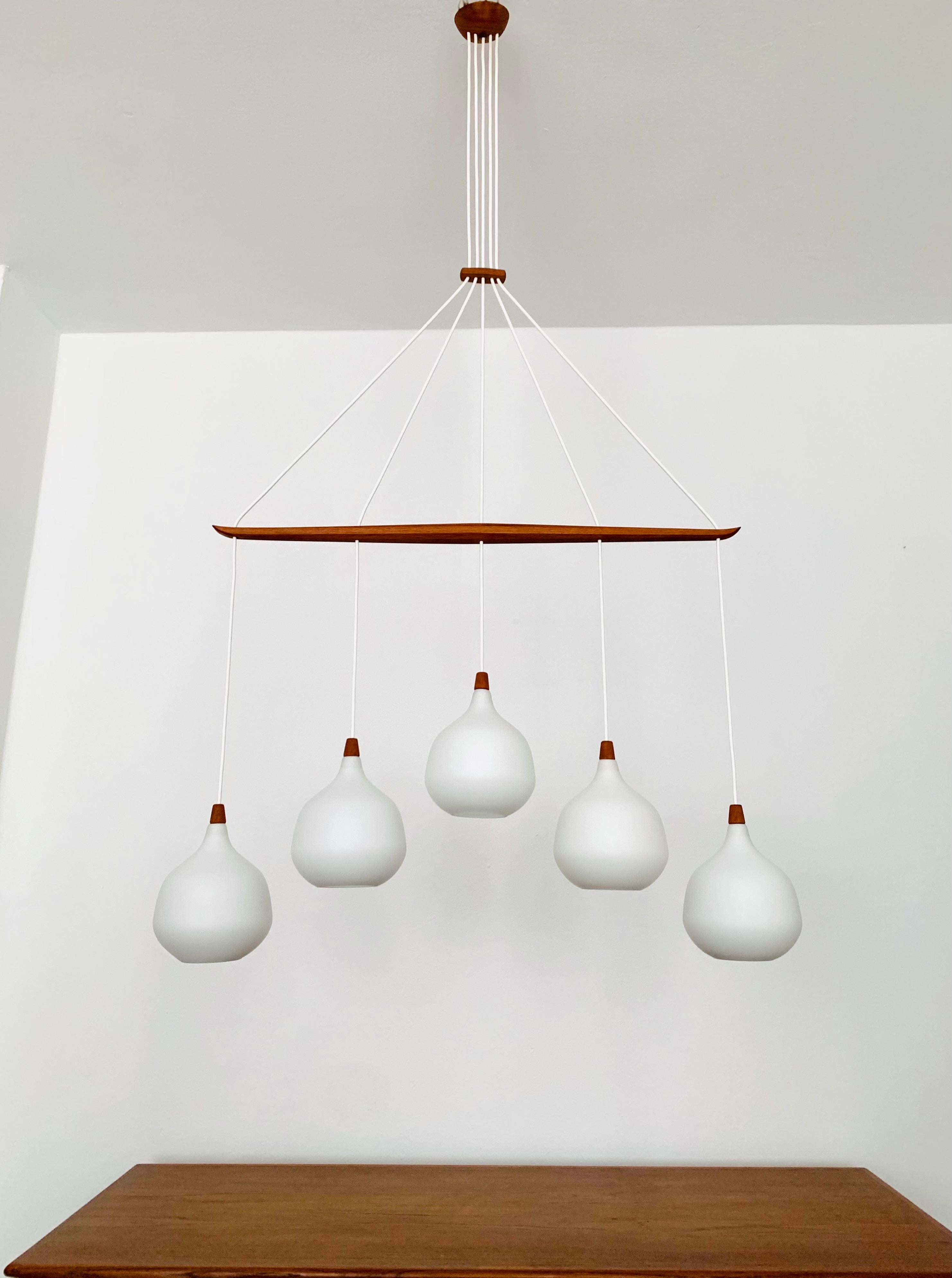 Wonderful Swedish opal glass chandelier from the 1960s.
Great and exceptionally minimalistic design with a fantastically elegant look.
Very nice teak details.
Very rare version in this design.

Manufacturer: Luxus
Design: Uno and Östen