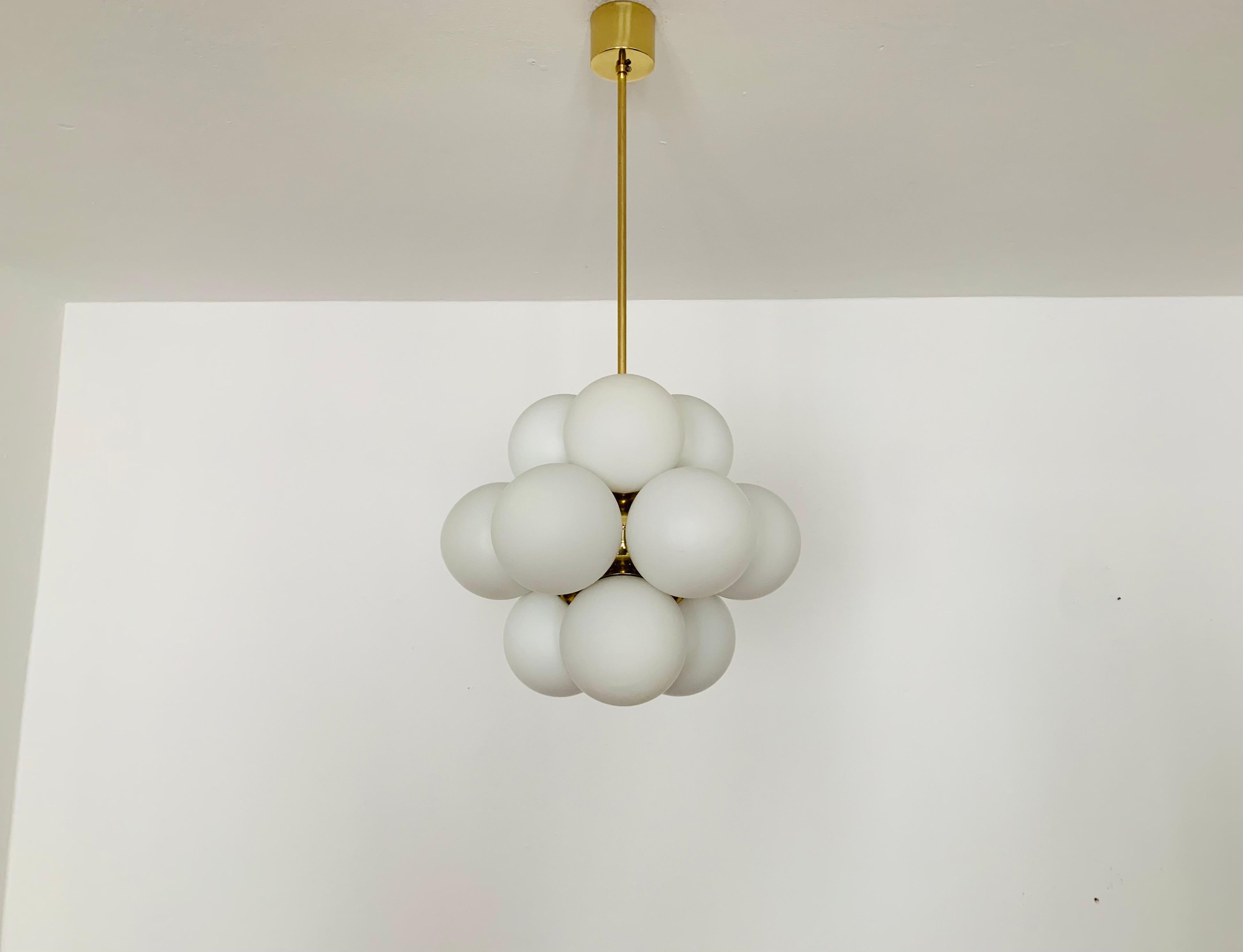 Extremely beautiful Sputnik chandelier from the 1960s.
The 12 opal glass lampshades spread a pleasant light.
The lamp has a very high quality finish.
Very contemporary design with a fantastic look.

Manufacturer: Kaiser Leuchten/ Kaiser