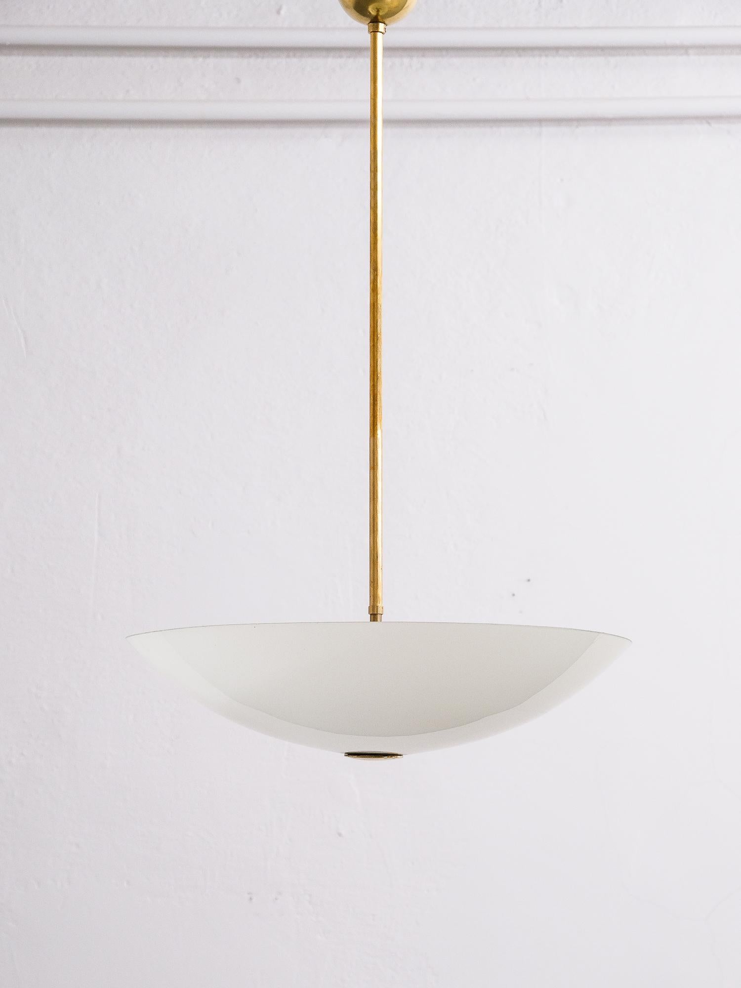 The lamp hangs from a brass stem and has three light bulbs and opaline glass shade.

Not stamped, possibly designed by Paavo Tynell for Idman/Taito Oy.