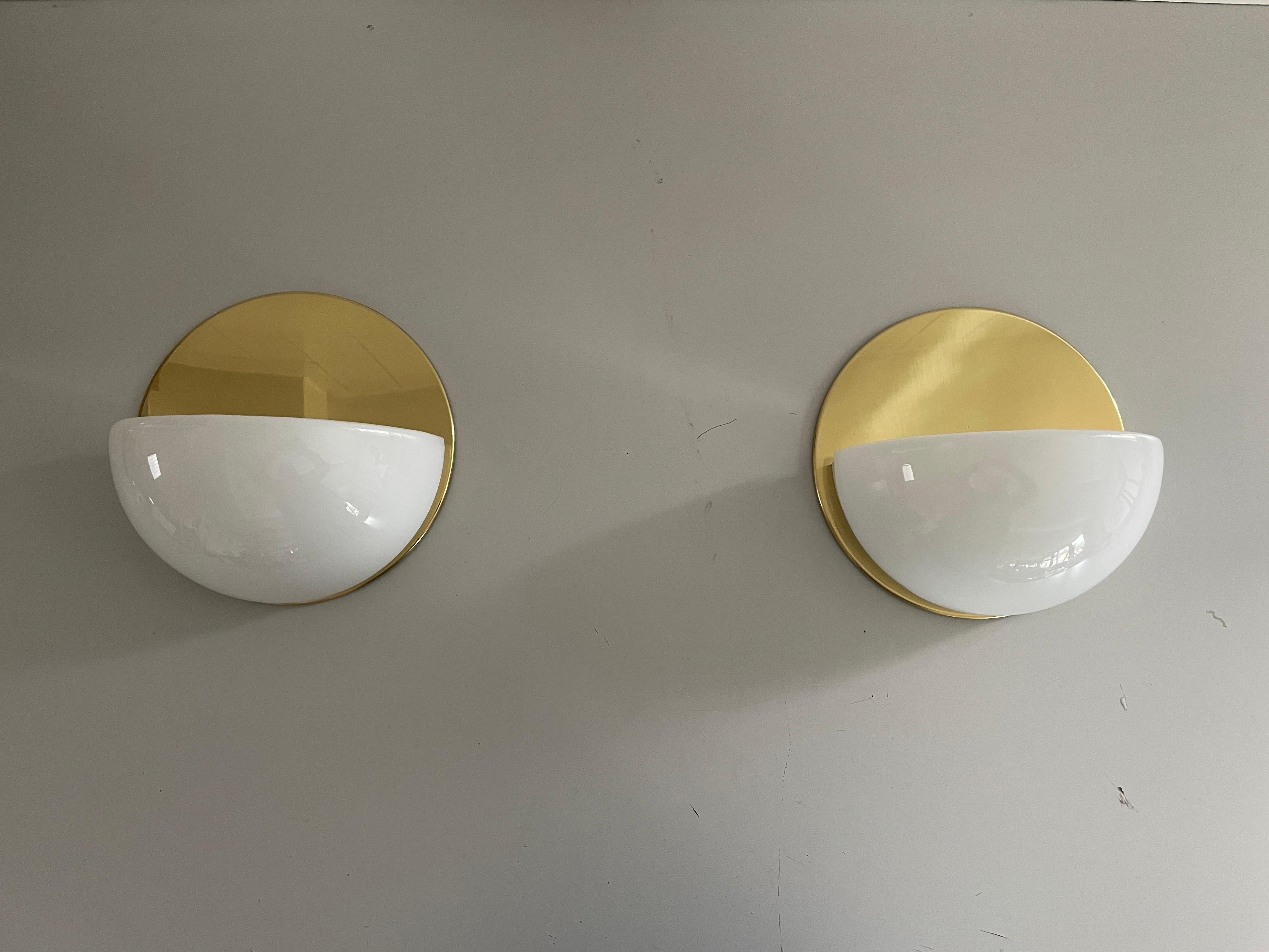 Opales Halbmondglas und runde Rückwand aus poliertem Messing, 1960er Jahre, Deutschland

Sehr elegante und minimalistische Wandlampen
Die Lampe ist in sehr gutem Zustand.

Diese Lampen funktionieren mit E27  Standard-Glühbirne. 
Verkabelt und für