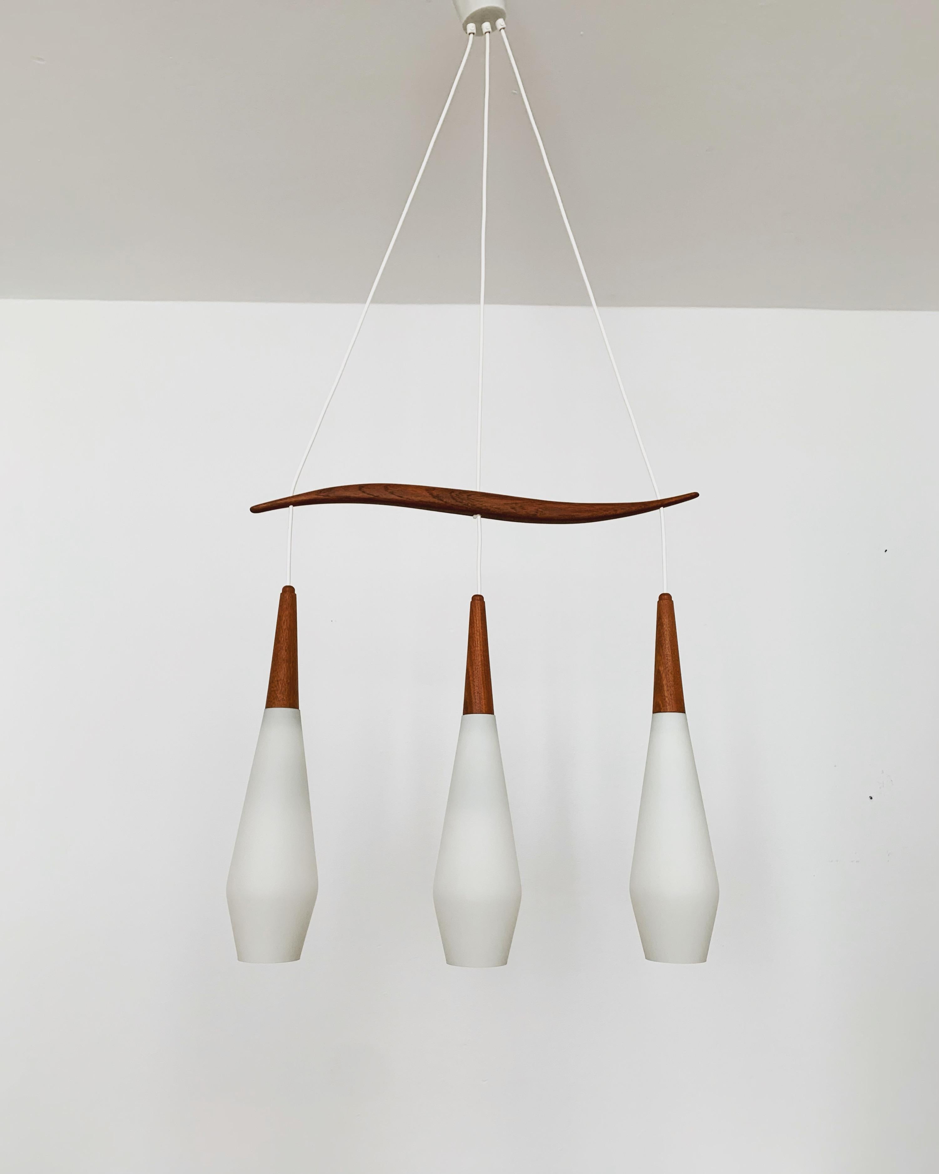 Wonderful opal glass pendant lamp from the 1960s.
Great and exceptionally minimalistic design with a fantastically elegant look.
Very nice teak details.

Condition:

Very good vintage condition with slight signs of wear consistent with