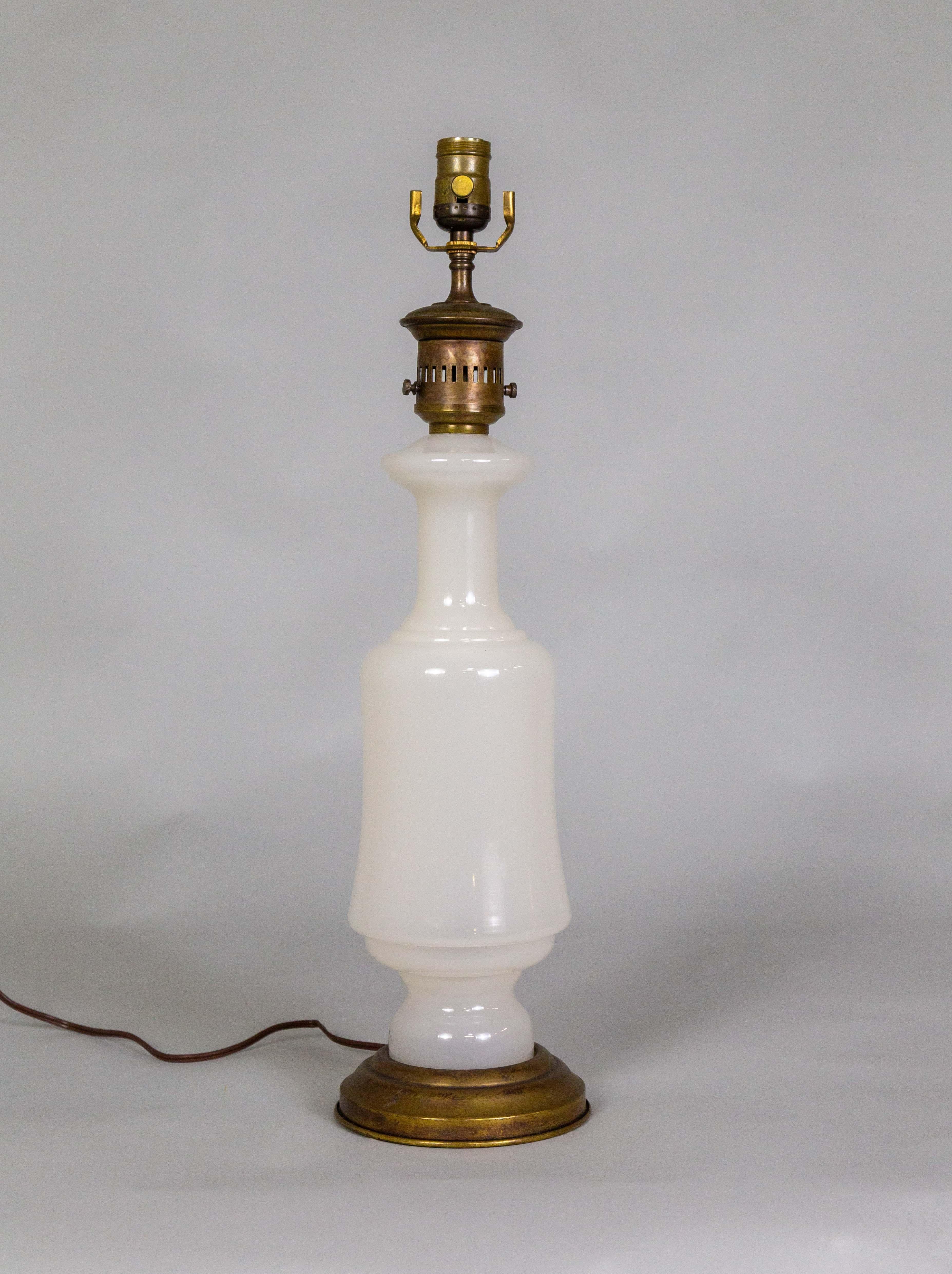 Une jolie lampe du milieu du 20e siècle de Frederick Cooper a des ferrures de lampe à pétrole au sommet d'un verre opalin laiteux aux formes élégantes. La base en laiton est assortie à la partie supérieure du cou. Le verre est fabriqué en France.