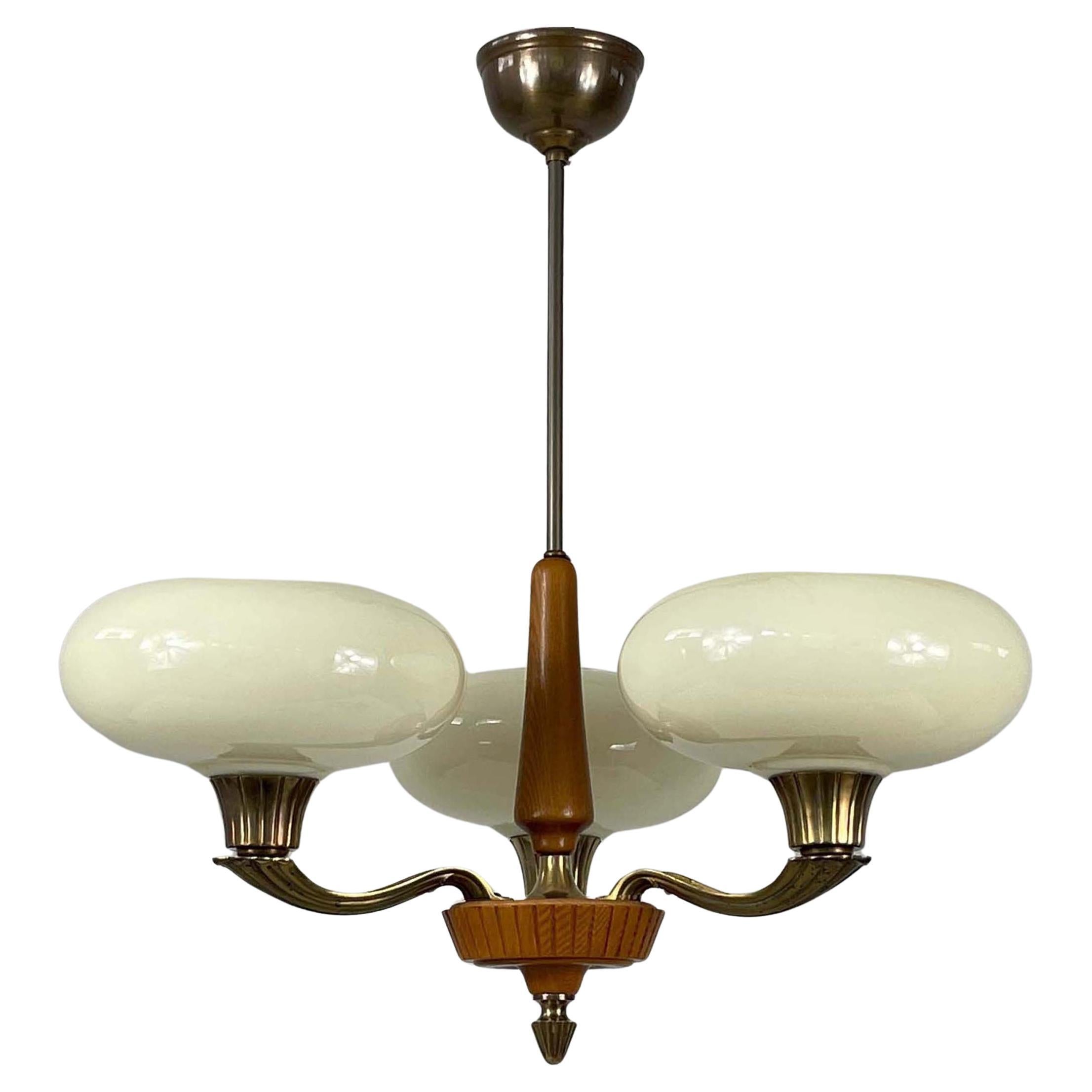 This rare, elegant Art Deco chandelier was designed and manufactured in Sweden in the 1930s to 1940s by Böhlmarks.

The chandelier features three rounded, bulbous shades, which have a smooth, flared shape. The opaline glass shades are a soft, warm,