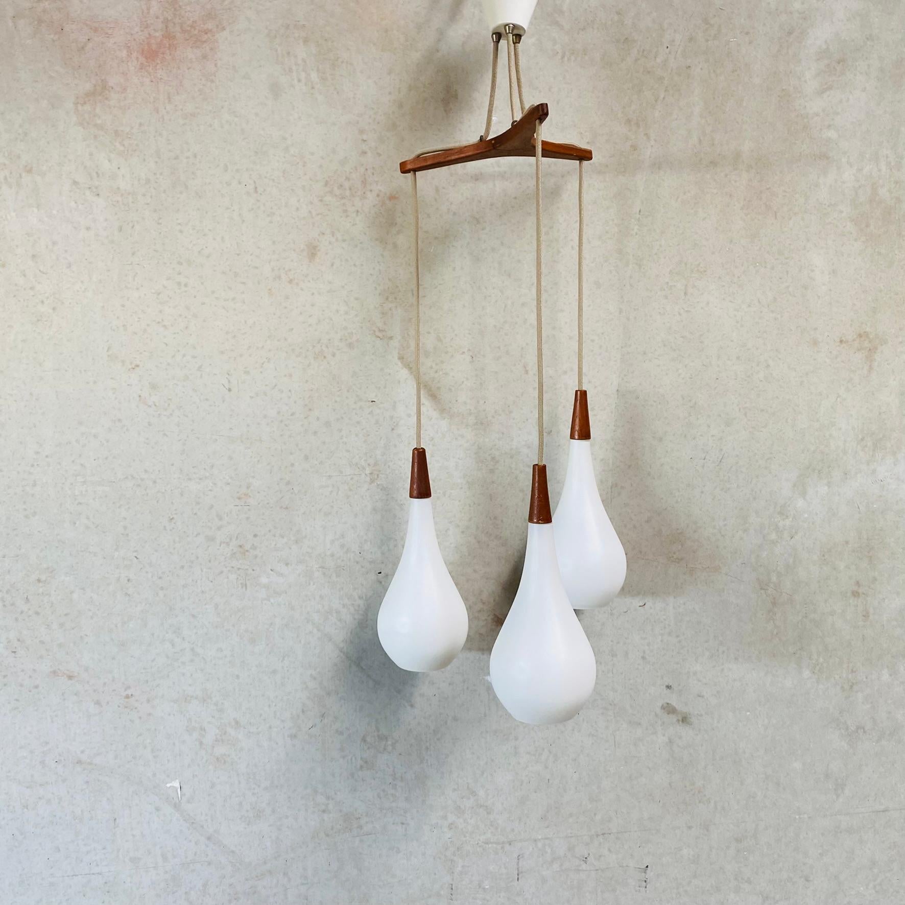 Introducing the Opaline Glass Triple Tear Drop Pendant Light by Holmegaard, Denmark 1960! This exquisite lighting fixture captures the essence of Scandinavian Modernist design, blending elegance, functionality, and timeless beauty. Crafted by the