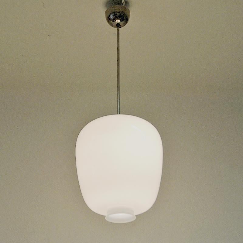 A Classic example of the modern Scandinavian design lighting. Pukeberg pendants are made from original glass moulds designed for Pukeberg Glassworks in the 1940s. These timeless opal glass shades have a chromed metal stem. The opening at the bottom