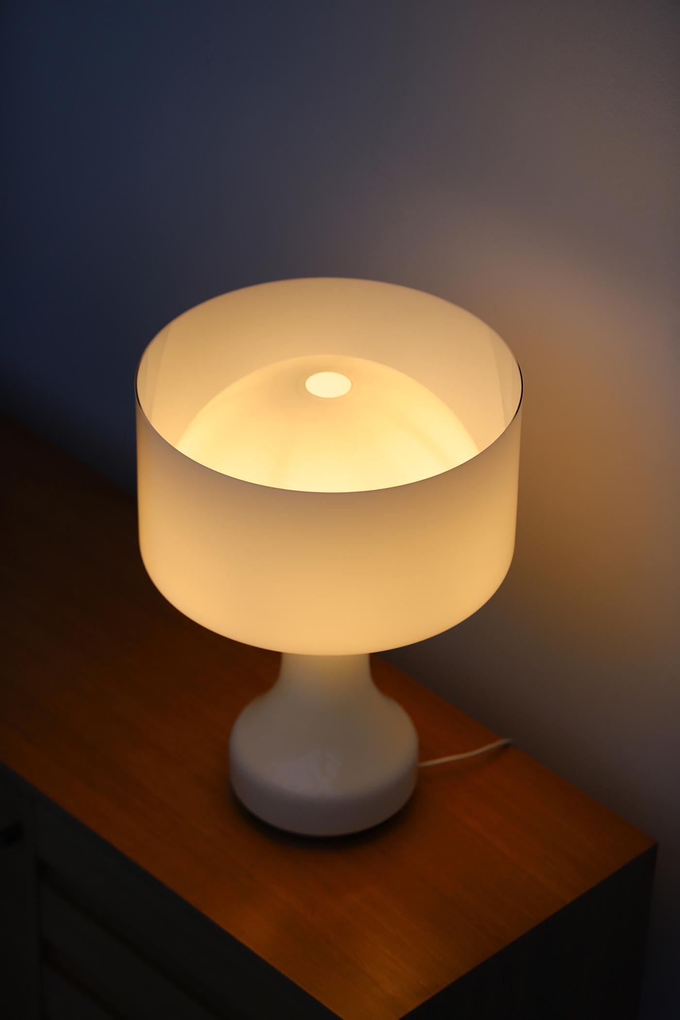 Lampada da tavolo in vetro soffiato a mano di Enrico Capuzzo per Vistosi. La lampada risale agli anni '60 ed è stata prodotta solo tra il 1962 e il 1963. La lampada è realizzata in vetro bianco opaco con un diffusore separato in vetro soffiato