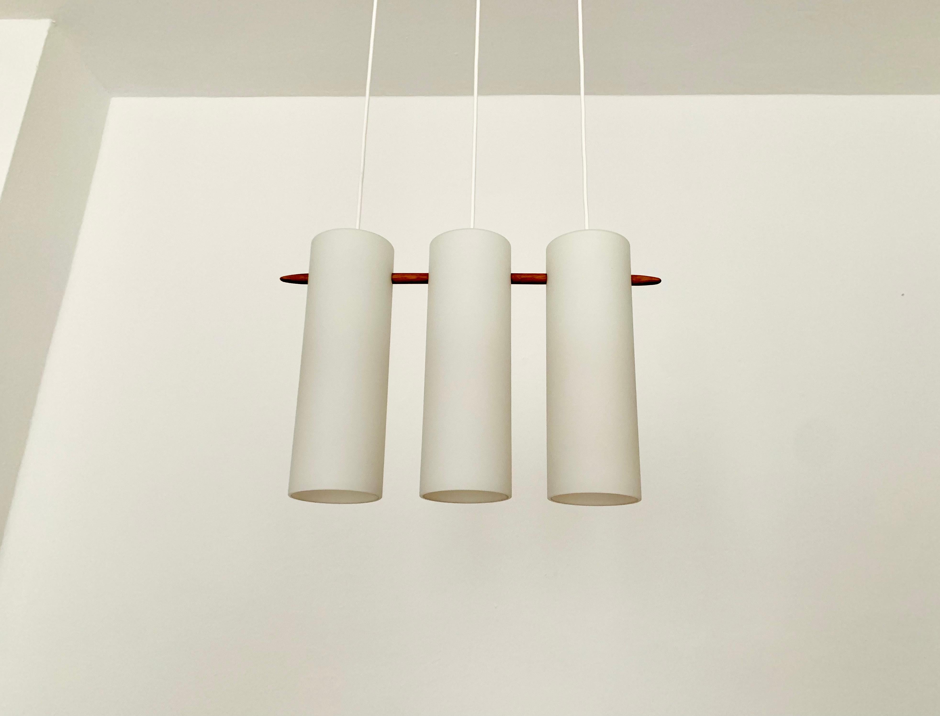 Wonderful Swedish opal glass pendant lamp from the 1960s.
Great and exceptionally minimalistic design with a fantastically elegant look.
Very nice details like the oak stick.

Manufacturer: Luxus
Design: Uno and Östen
