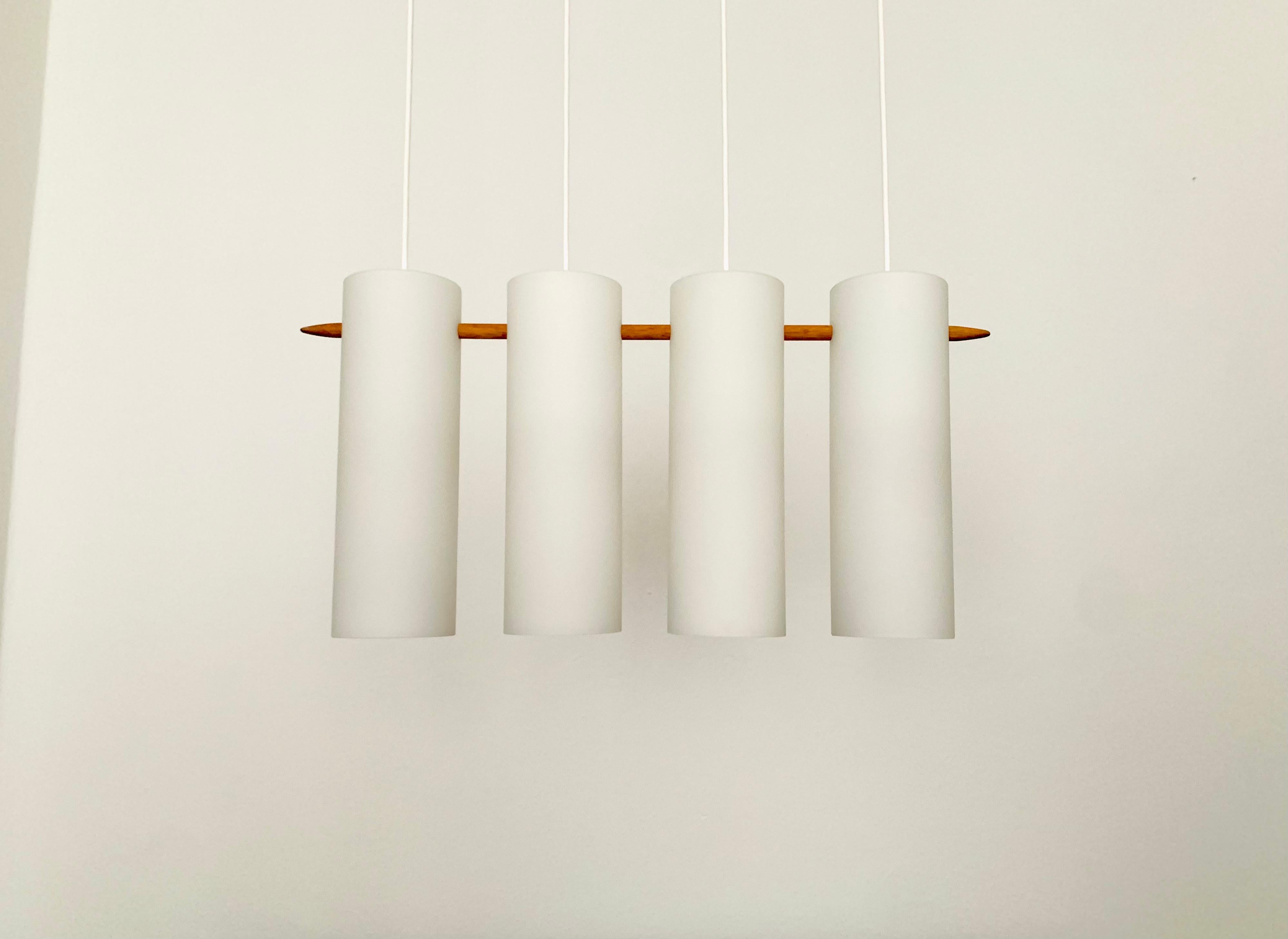 Wonderful Swedish opal glass pendant lamp from the 1960s.
Great and exceptionally minimalistic design with a fantastically elegant look.
Very nice details like the oak stick.

Manufacturer: Luxus
Design: Uno and Östen