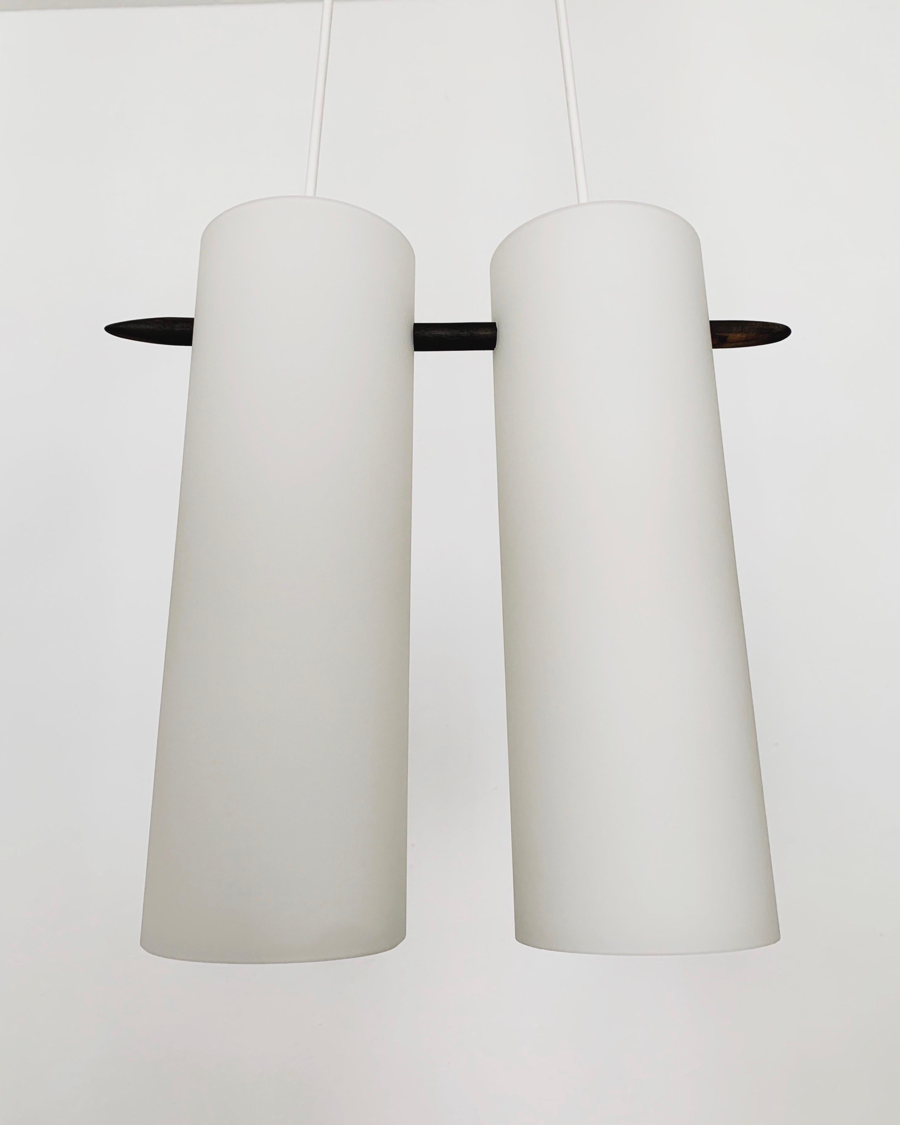 Wonderful Swedish opal glass pendant lamp from the 1960s.
Great and exceptionally minimalistic design with a fantastically elegant look.
Very nice details like the ebonized stick.

Manufacturer: Luxus
Design: Uno and Östen