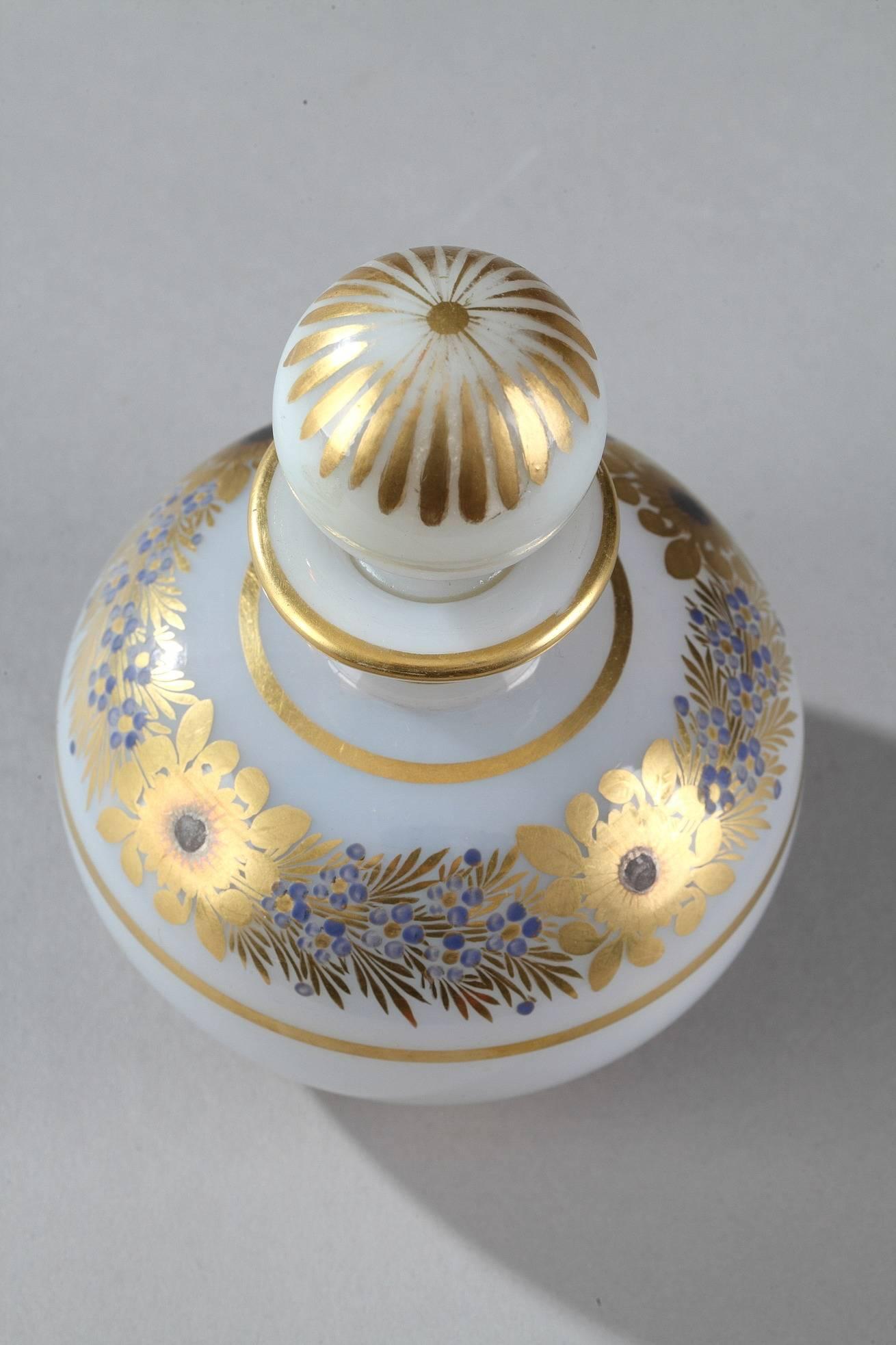 Restauration perfume bottle with its ball-shaped stopper in bulle de savon (soap bubble) opaline. A wreath of gold and blue anemones and forget-me-nots is surrounded by gilded bands, which also adorn the neck. The stopper is topped with petals. This
