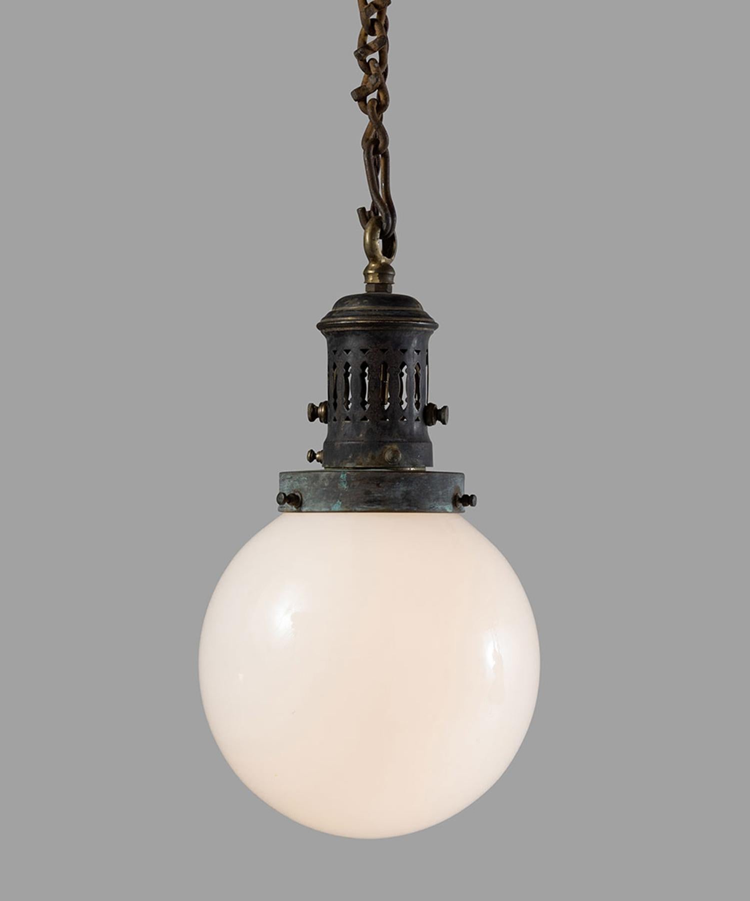 Opaline globe pendant with heavily patinated brass fitter and canopy.

 