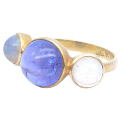Opals and tanzanite cabochon ring in yellow gold