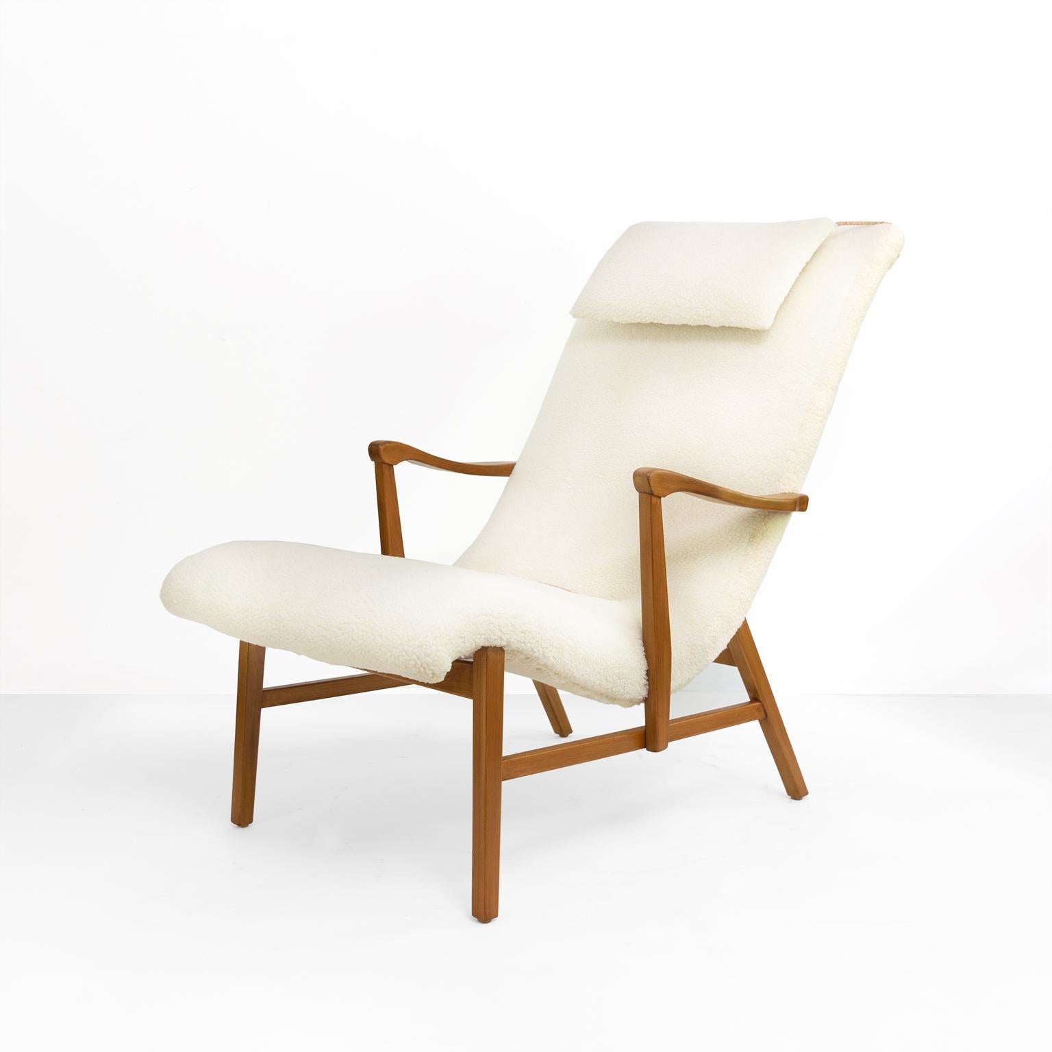 A Scandinavian Modern lounge chair with newly restored stained beech wood frame. The chair has been newly upholstered in faux sheepskin upholstery fabric. Detailed with leather cords and button, a head pillow adds extra comfort. 

Total height: 37”,