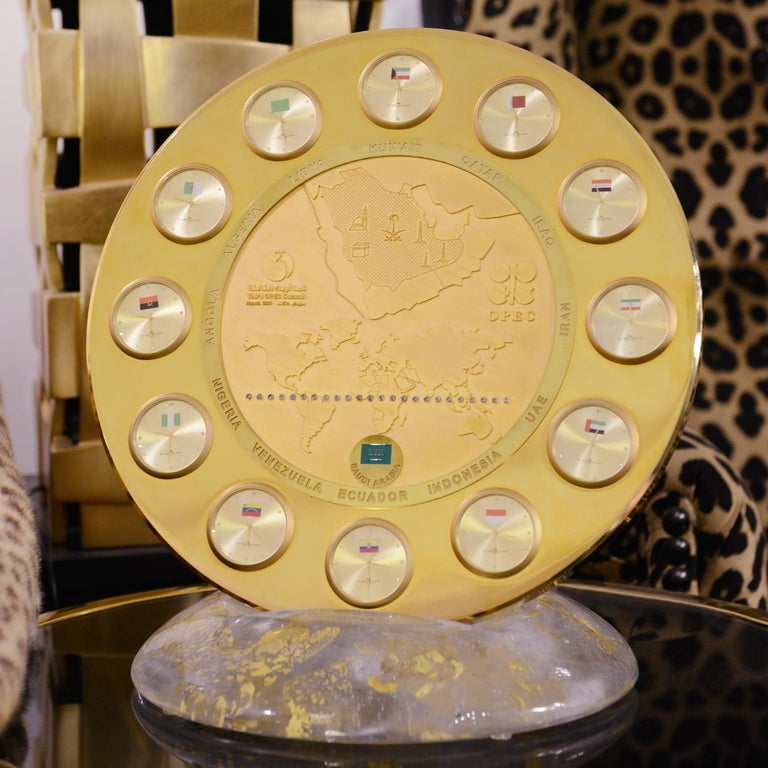 Clock OPEC Gold, with gold and solid brass in polished finish,
With 12 clocks with convex clear glass. Round center map of OPEC's 
members with amber diodes indicating sun position. With gold leaf taken 
into the Murano glass base. This clock has