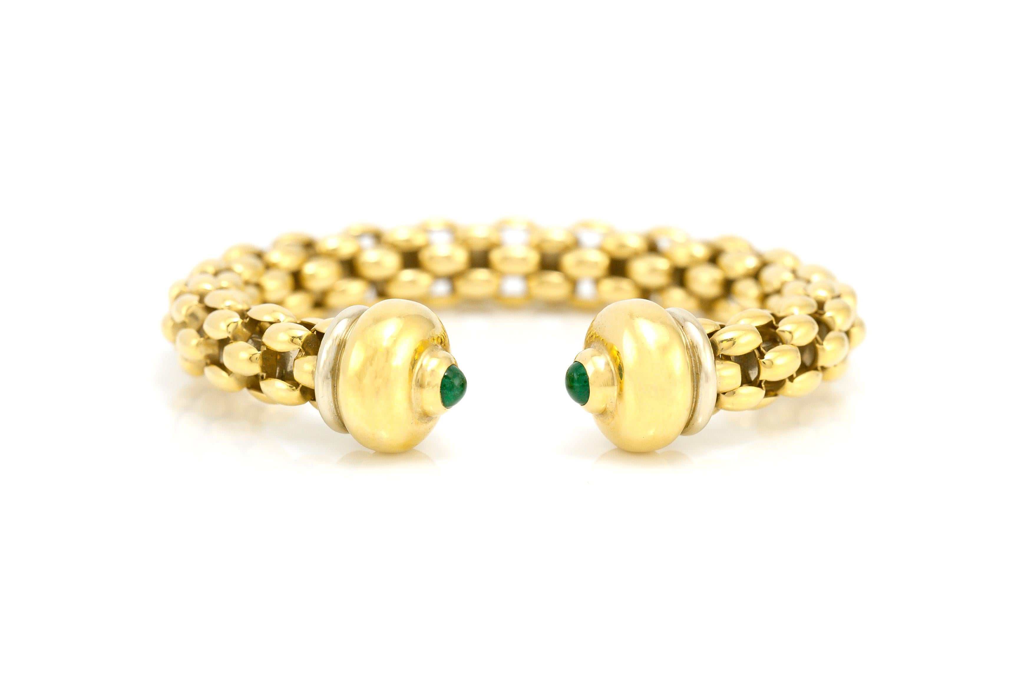 The bracelet is finely crafted in 18k yellow gold with two cabochon emeralds and the wighing approximaately is 33.3 dwt.