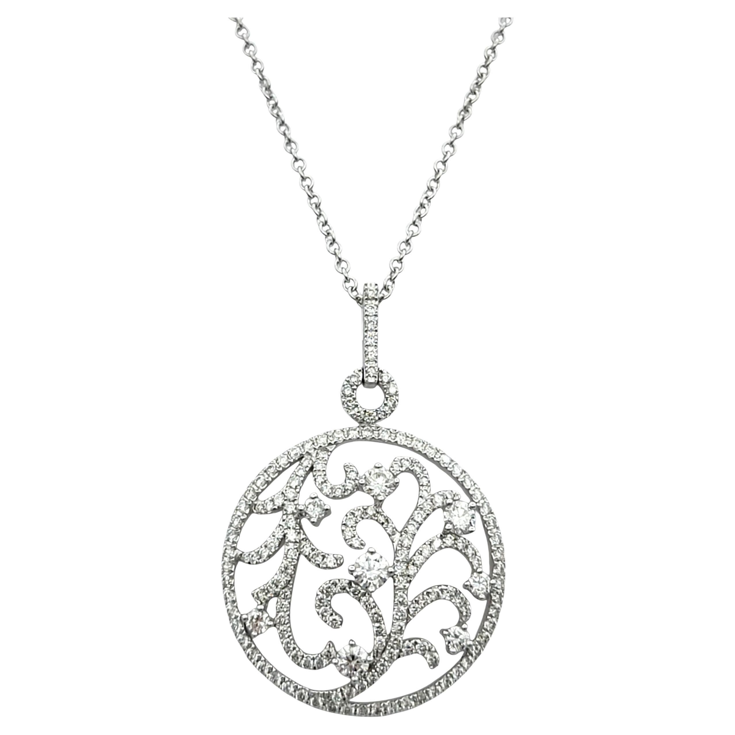 Cet exquis collier pendentif en or blanc 14 carats présente un étonnant design en cercle ouvert d'inspiration botanique, orné de diamants brillants. Au cœur du pendentif, des vignes à l'enroulement complexe sont délicatement soulignées de diamants