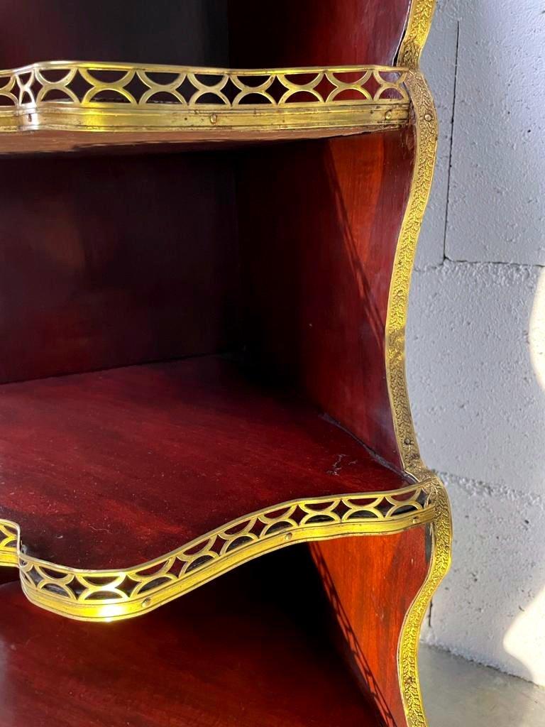 Superb open corner shelf scalloped in solid rosewood and rosewood veneer resting on feet. It consists of 5 shelves, all elegantly surrounded by a finely chiseled brass gallery.

Period: 19th century - Second Empire
Measures: H: 126 x W: