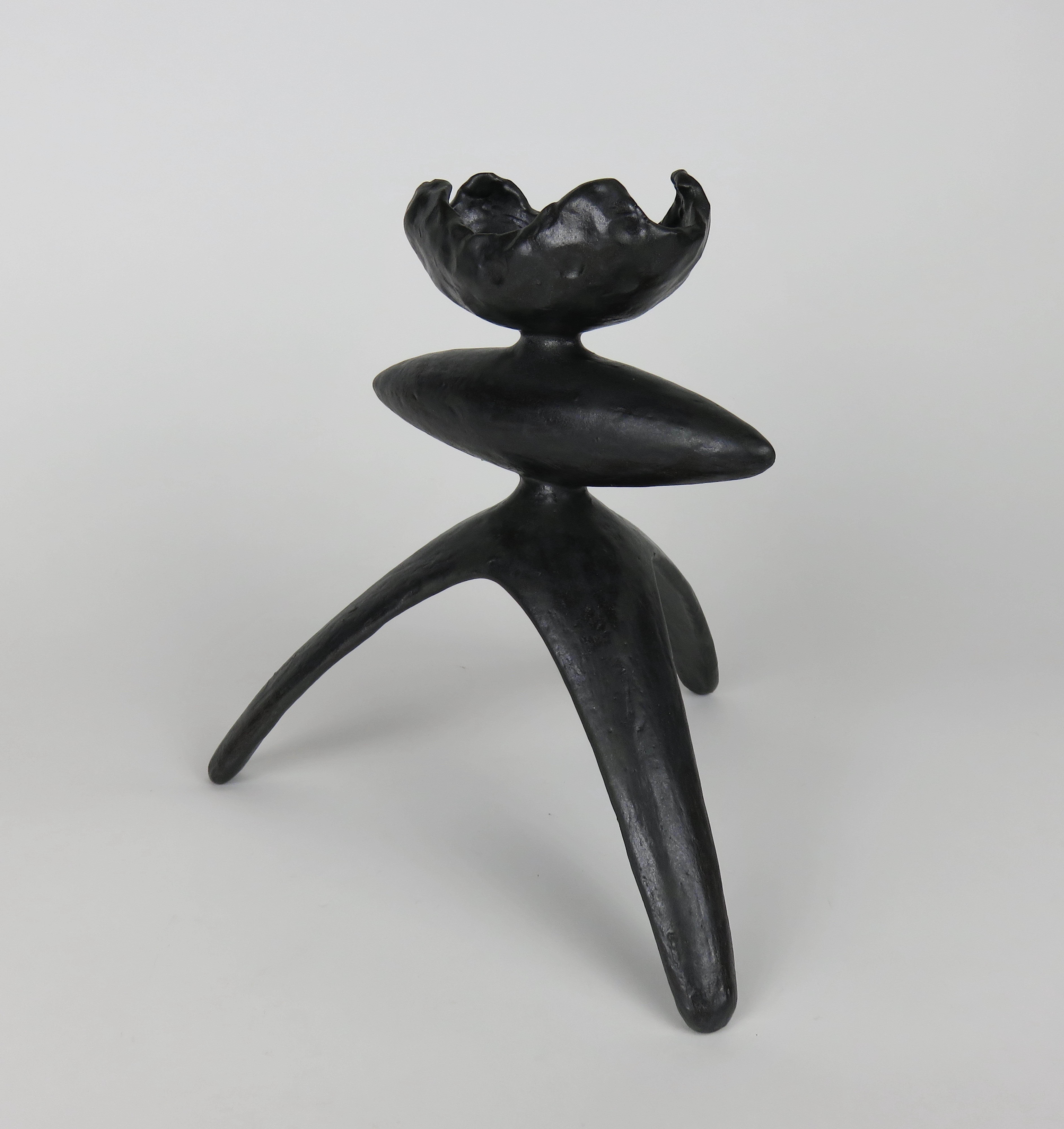 Hand built ceramic sculpture in mottled black glaze. This piece, one in a series of Modern TOTEMS has a crimped curve open top, an elongated center form, tripod legs and a luscious black glaze. Each part is hand-formed then attached together before