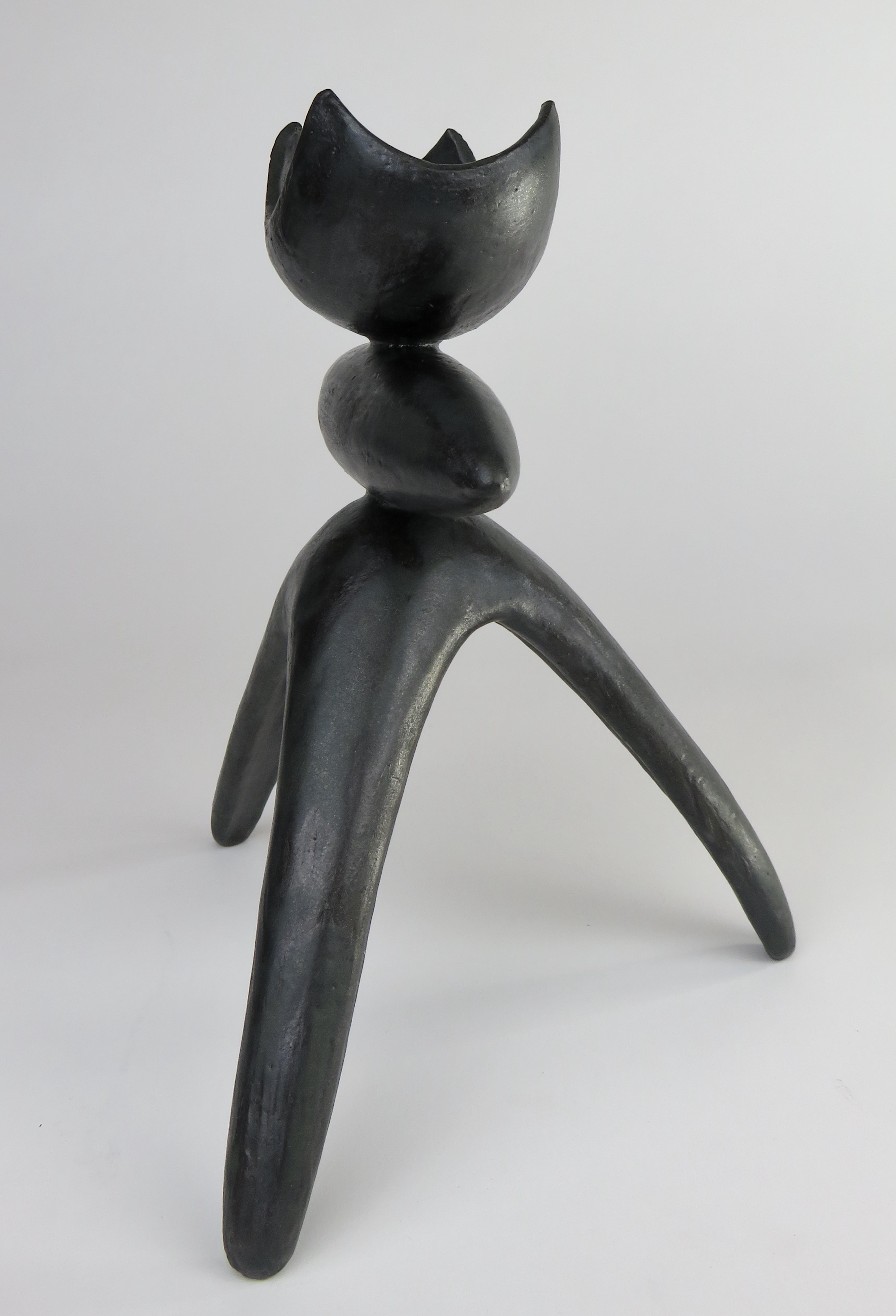 This glazed black hand built ceramic Modern TOTEM consists of an open arc'd top with a middle elliptical shape on tripod legs. Part of a series of Modern Totemic works. The dark brown stoneware clay is hand formed in 3 sections which are attached