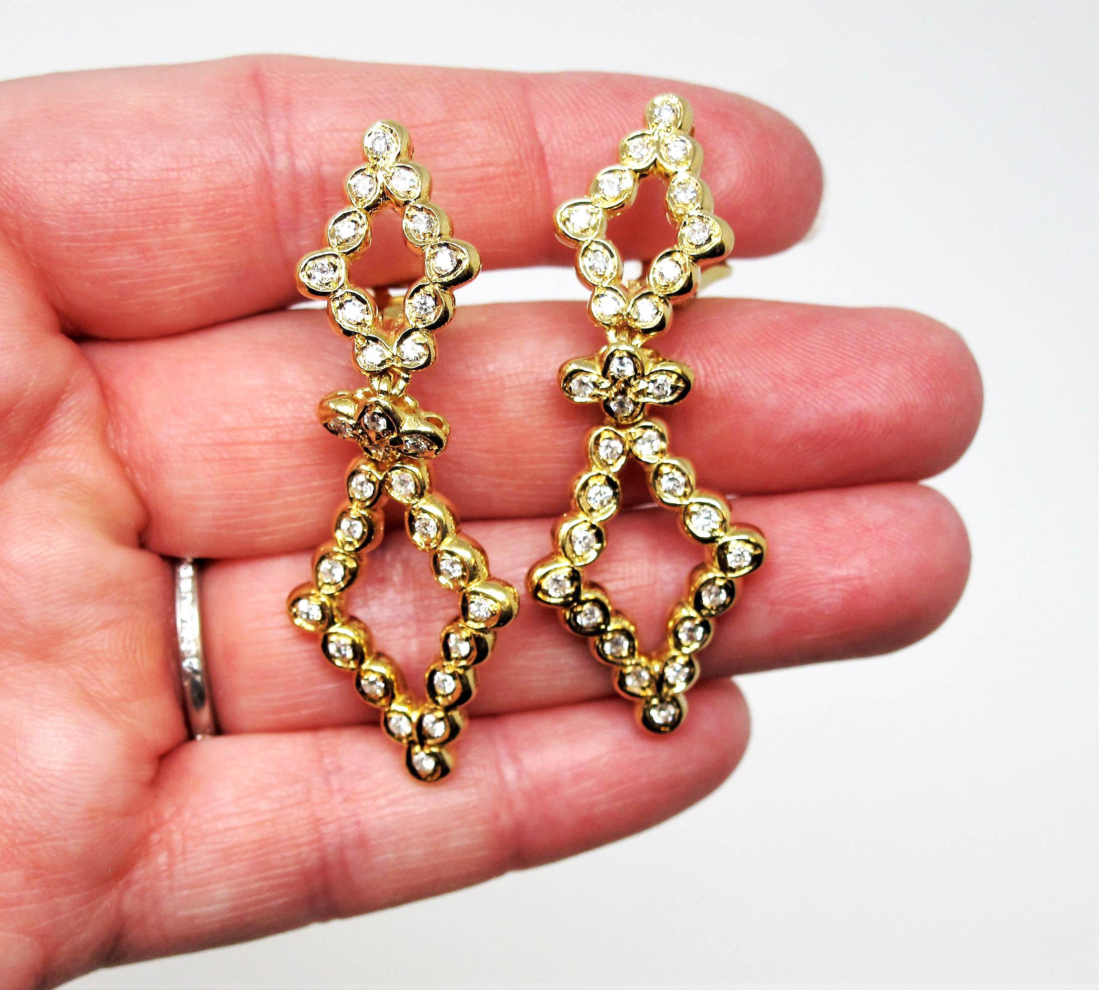 Brilliant diamond drop earrings set in 18 karat yellow gold. Featuring a double open diamond shaped arrangement, these super sparkly stunners dangle gently and glimmer from all angles. The elongated shape offers a flattering feminine fit, while the
