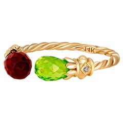  Open ended gold ring with peridot, garnet and diamonds