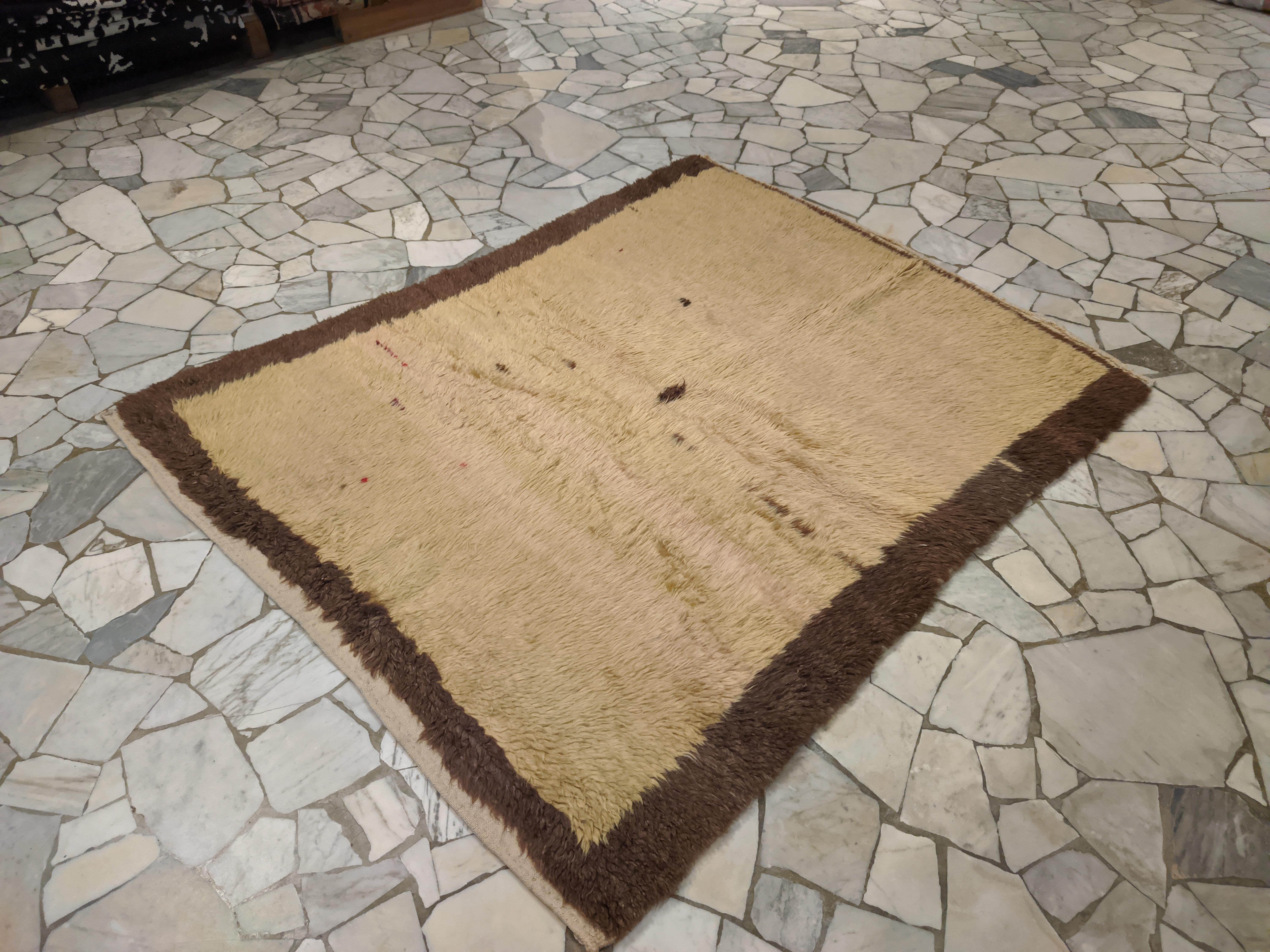 Dieser Tulu zeichnet sich durch ein für Yatak-Teppiche typisches quadratisches Format aus und hat einen weichen, cremegelben Hintergrund, der nach dem Zufallsprinzip von kleinen Punkten und einem größeren Punkt in der Mitte unterbrochen wird.
