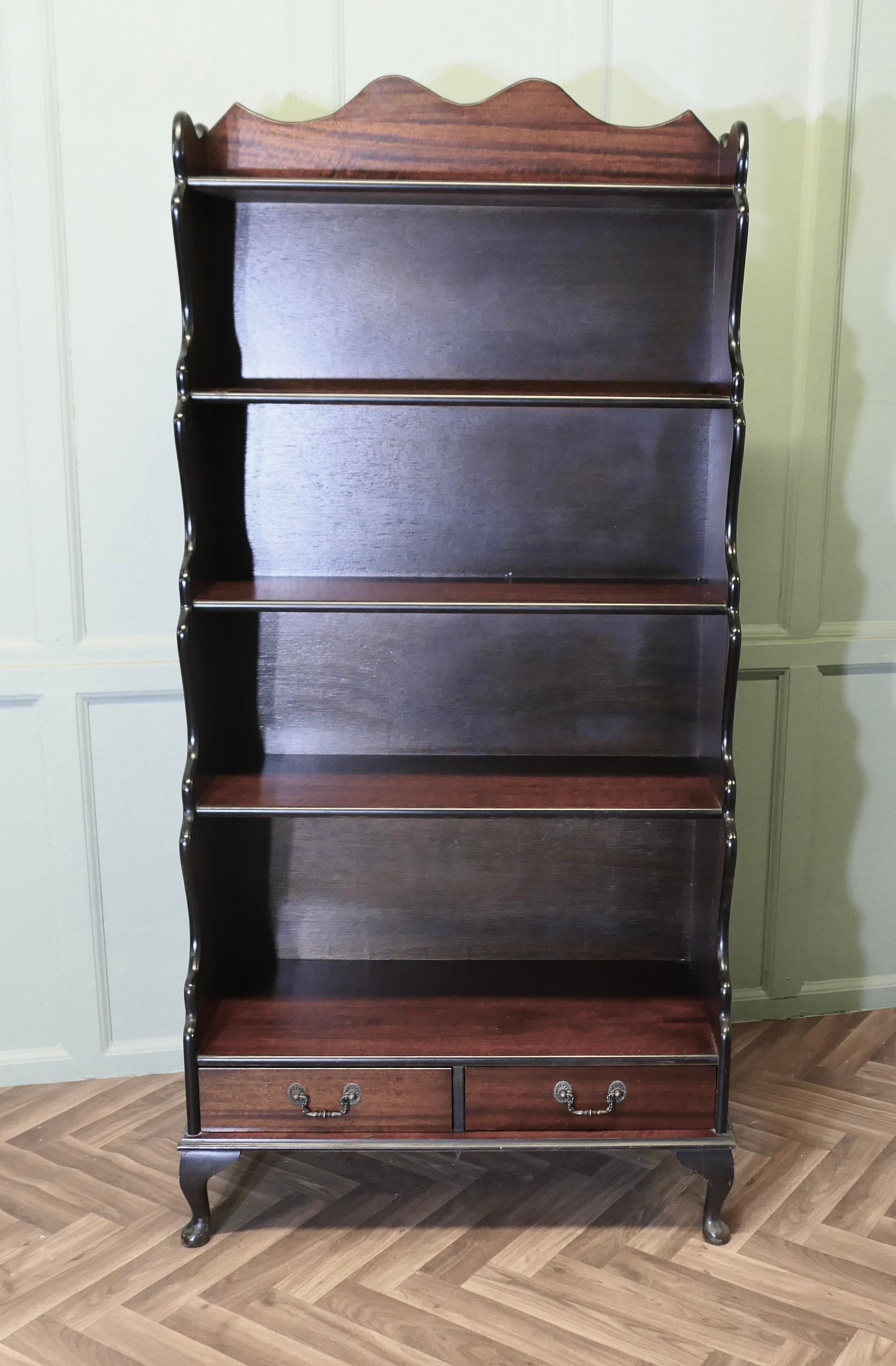 Open Front Waterfall Bookcase with Drawers

This is an excellently designed and attractive piece, it has scalloped sides with a gallery around the top shelf and 2 drawers at the bottom 

The book case has five shelves and it stands on small cabriole