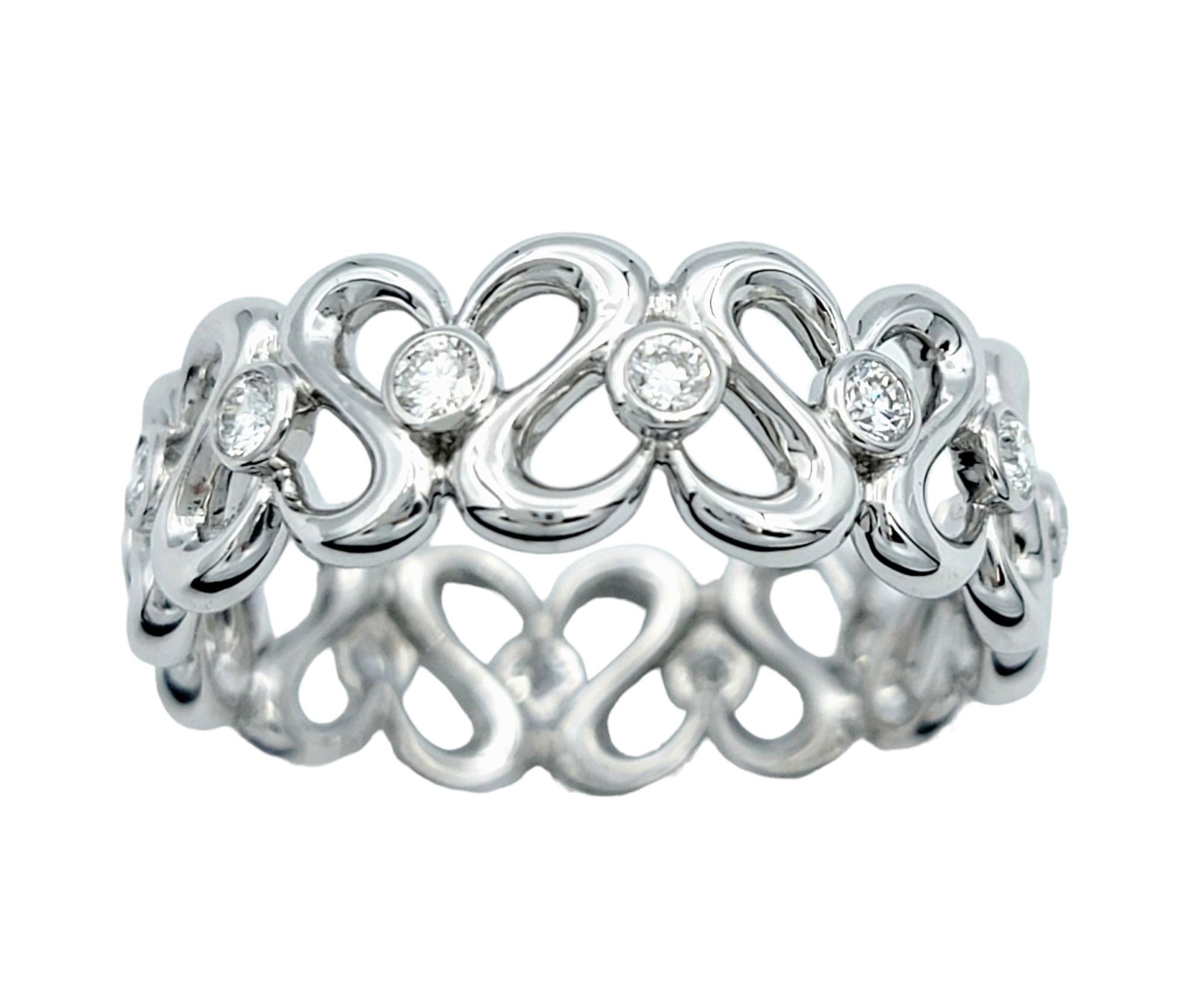 Ring Size: 7.75

This beautiful band ring, set in elegant 18 karat white gold, features a delightful open heart motif design that exudes charm and romance. A continuous loop forms various hearts, each adorned with a sparkling diamond at its center.