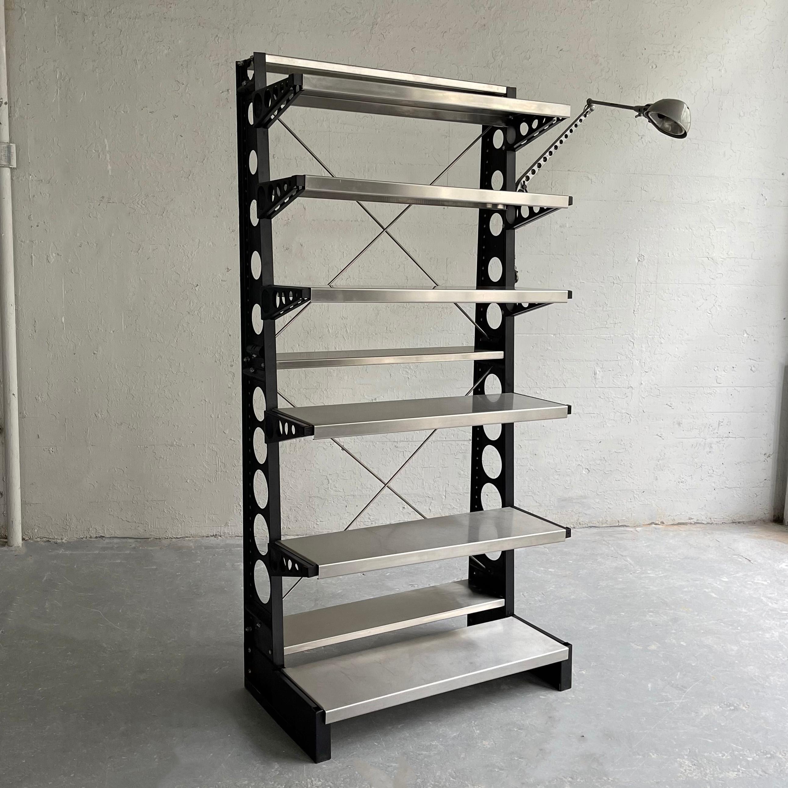Industrial, open shelving unit with attached 41 inch task lamp features circular perforated steel uprights with 9 stainless steel shelves. The front shelves are 12 inches deep and the back shelves are 7.5 inches deep with 13.5 inches of clearance
