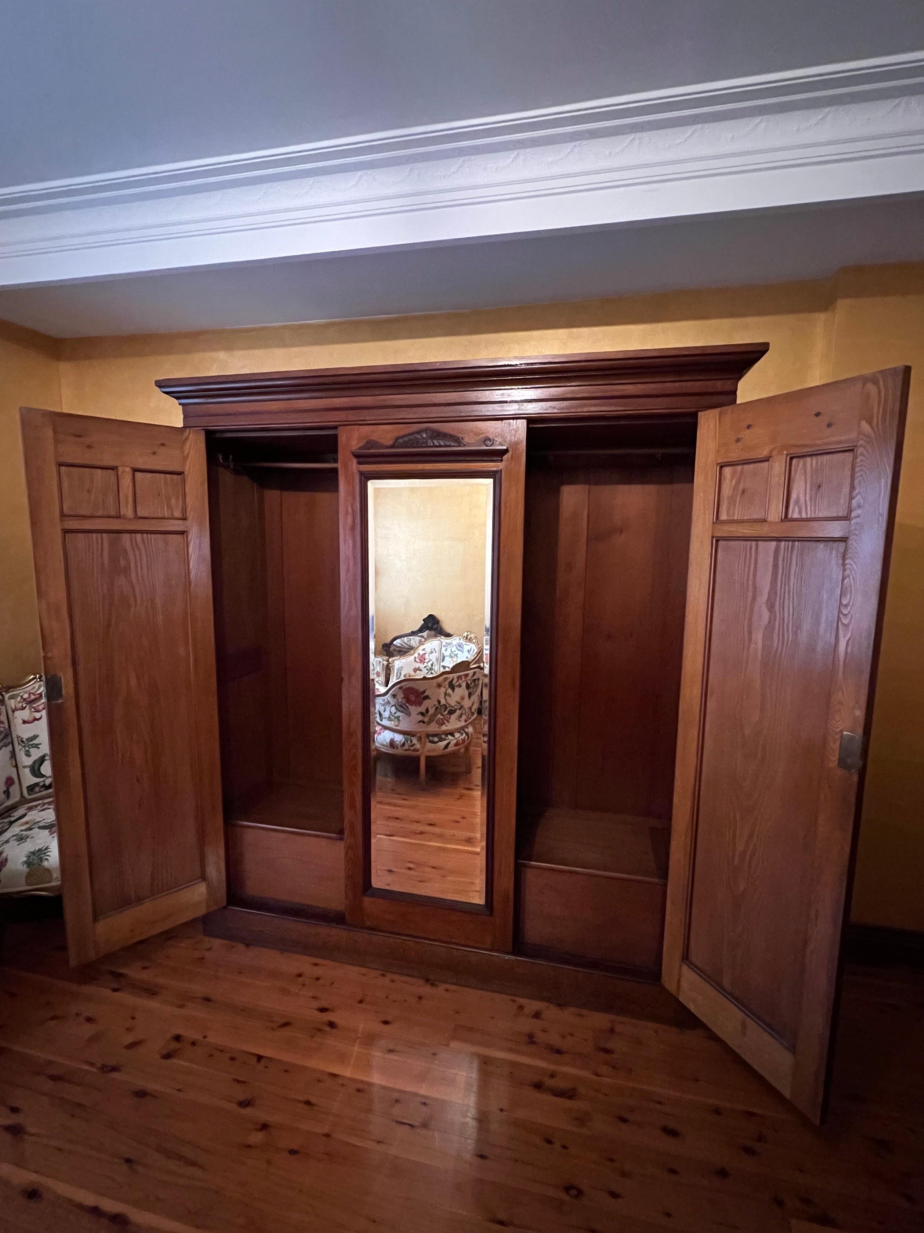 Both sides of cupboard are hanging racks with tow doors and centre mirror, open door cupboards on the base of the cupboard, comes with keys, comes apart in smaller pieces for easer transport. Has makers stamped of Anthony Hordens & Sons. 

Circa: