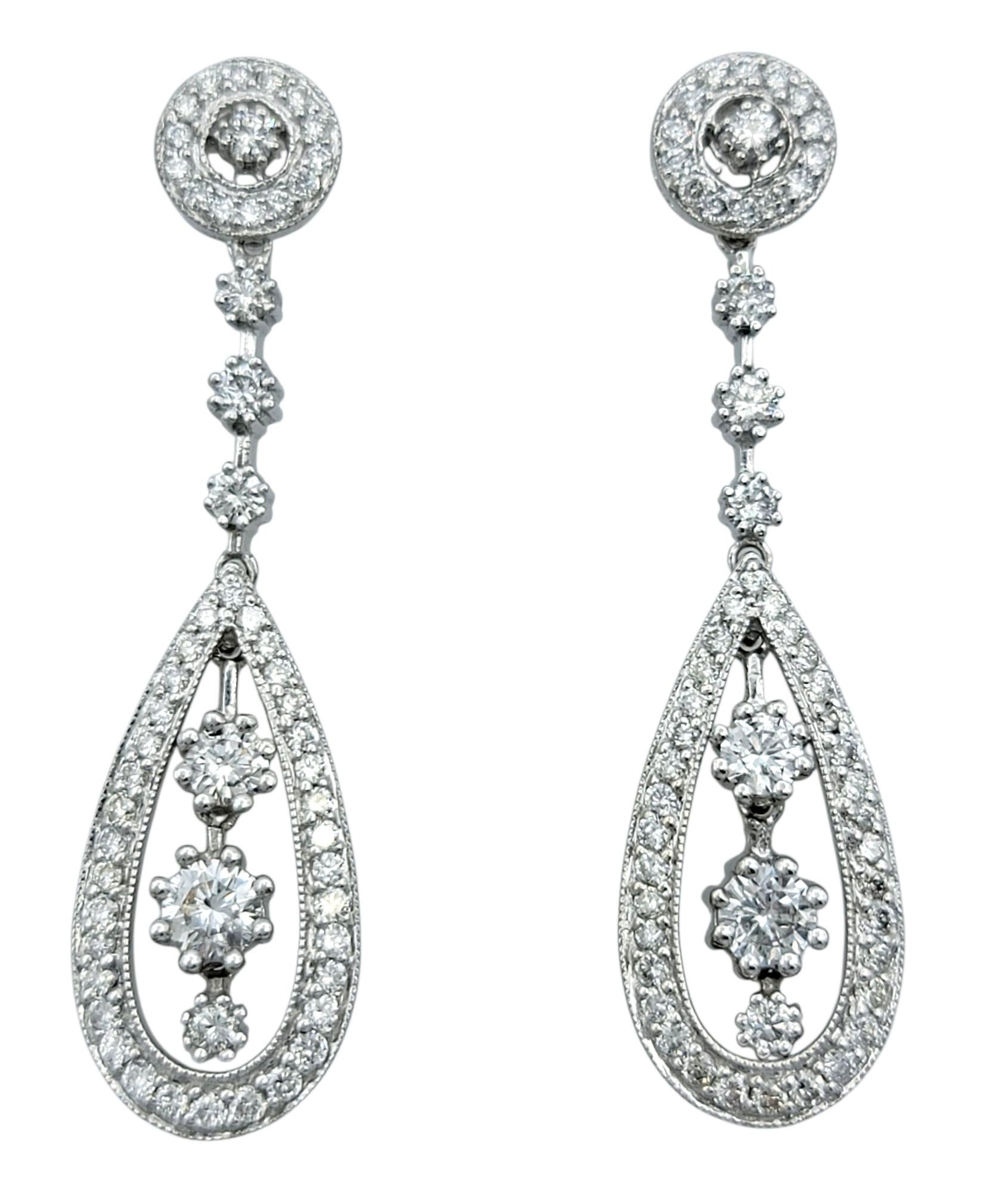 These dazzling drop earrings feature a sophisticated pear-shaped silhouette, dripping with round brilliant diamonds that catch the light at every angle. The top stud anchors a graceful cascade of diamonds leading to an open teardrop frame, adding