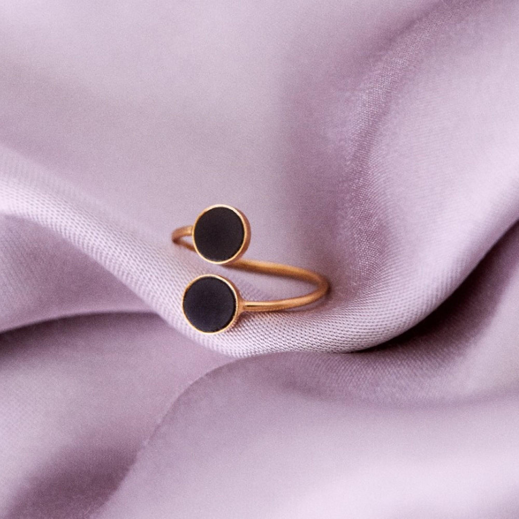 Our gold open ring is a subtle and unique accessory. The ring beautifully embraces the finger, while two deep-coloured stones give it an edgy touch. The ring fits perfectly with both classic and modern stylings.
The ring is decorated with a