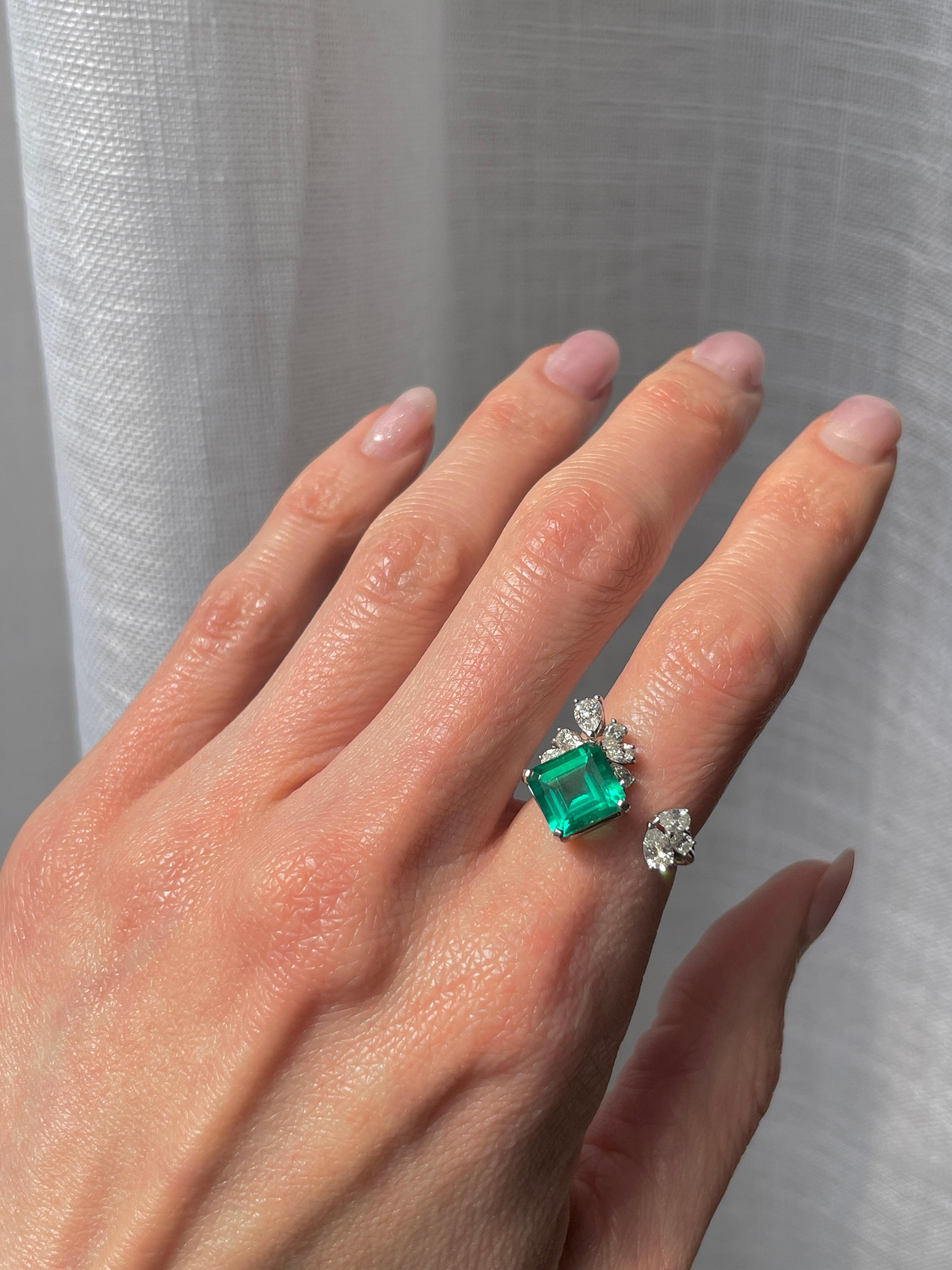 A unique and playful design to showcase a serious stone. This 4.27 carat Zambian emerald is low oil certified by AGL, eye clean, and a particularly vibrant green color.

The surrounding clusters are made of GH VS+ natural diamonds, totaling 0.90