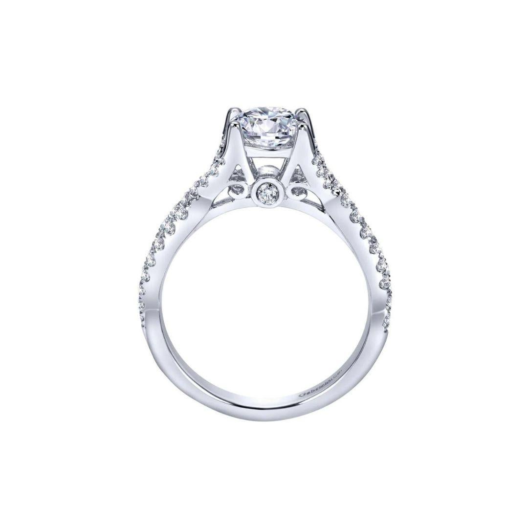 Ladies' 14k White Gold Diamond Engagement Mounting. Diamond pave weaves the split shank of this gorgeous ring to a delicate open rise, embracing the center stone gracefully. A bezel round diamond underneath the center stone adds subdued