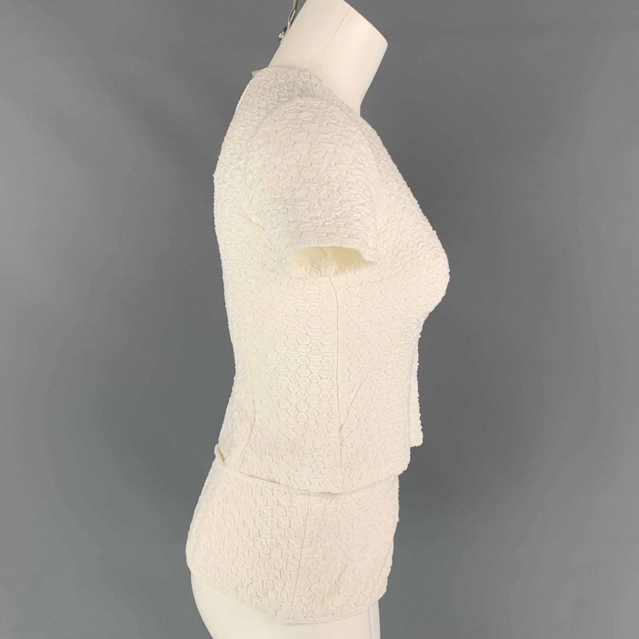 Die Bluse OPENING CEREMONY ist aus einer weißen, strukturierten Viskosemischung gefertigt und verfügt über eine verlängerte Lage, eine Netzleiste und einen Knopfverschluss auf der Rückseite. Hergestellt in den USA, sehr gut
Gebrauchtes Zustand.
