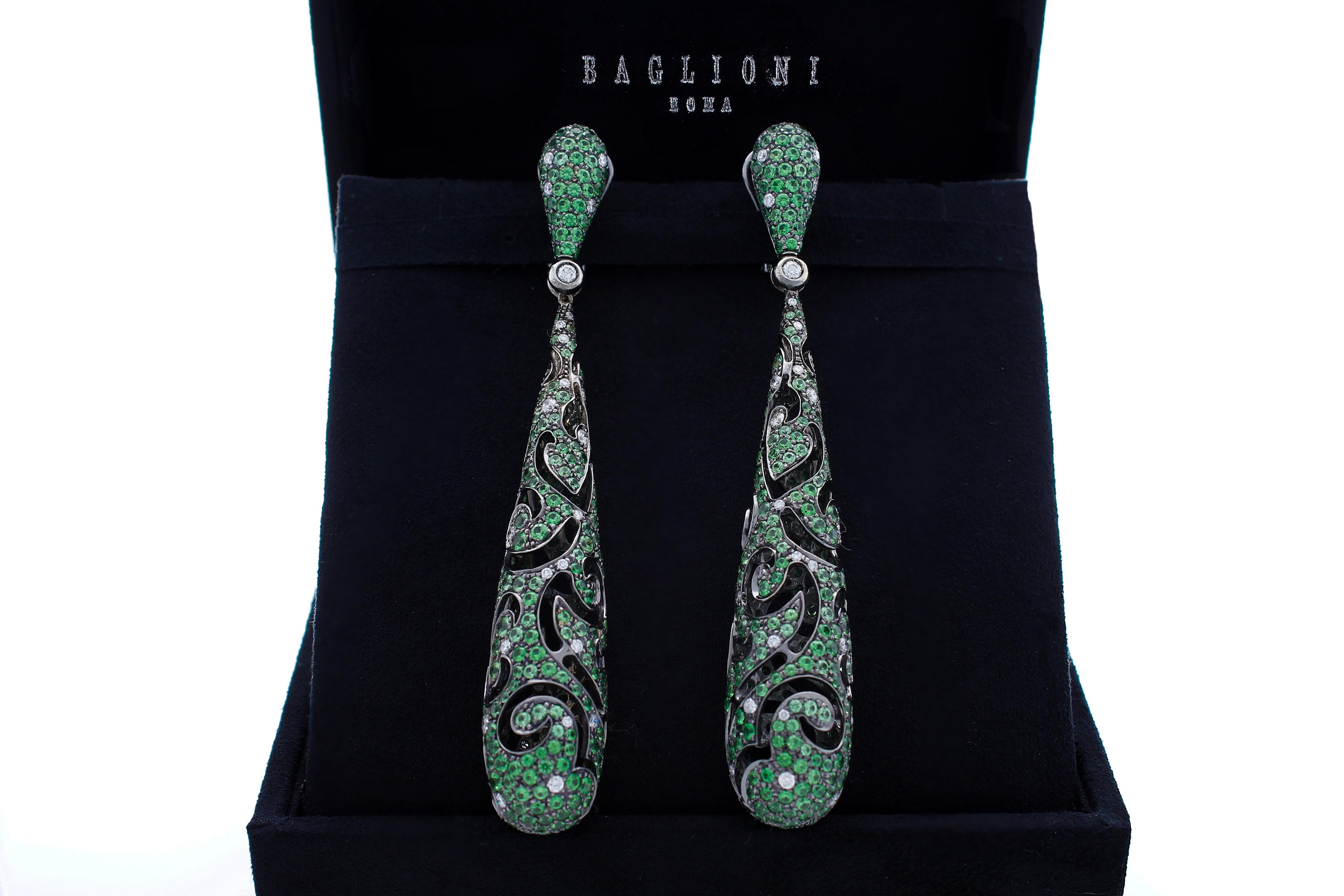 Drop-shaped pendant earrings, entirely pierced with emerald pave with a total weight of 16.74 ct and diamonds with a total weight of 1.63 ct. 
The earrings are in burnished 18 Kt white gold. 
The closure is with clips with the pin that can be