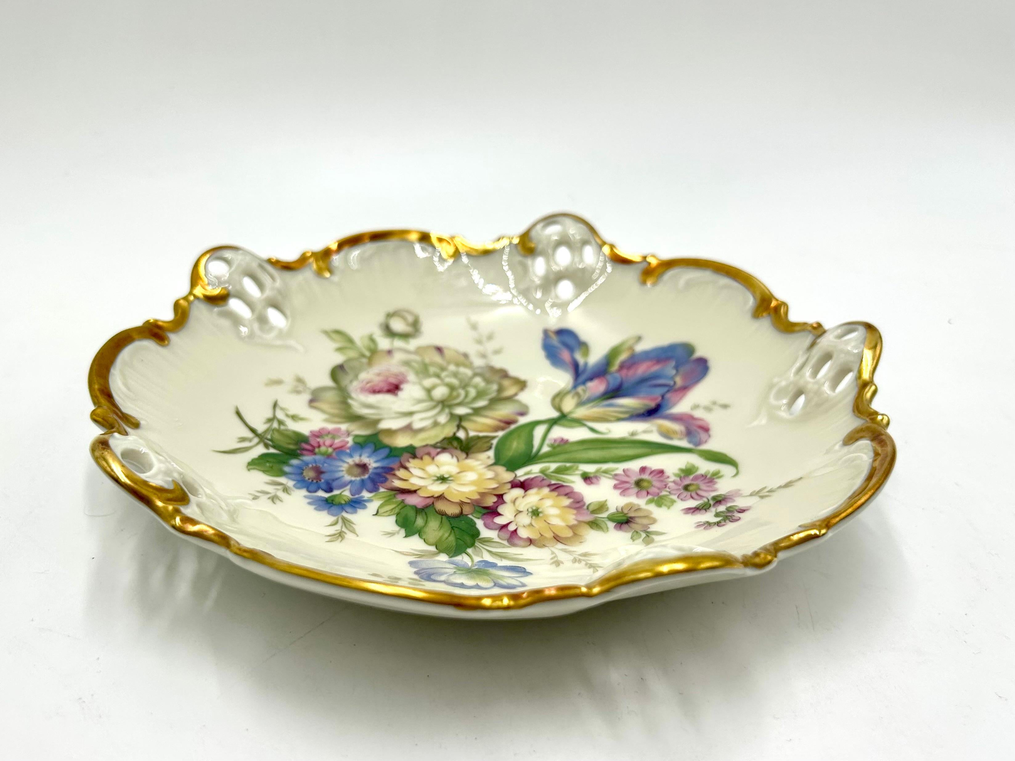 A plate with openwork sides from the Moliere series by the renowned German Rosenthal porcelain factory.

Ecru porcelain decorated with gilding on the edges and a floral bouquet motif.

Signed with the mark of the manufacturer from the years