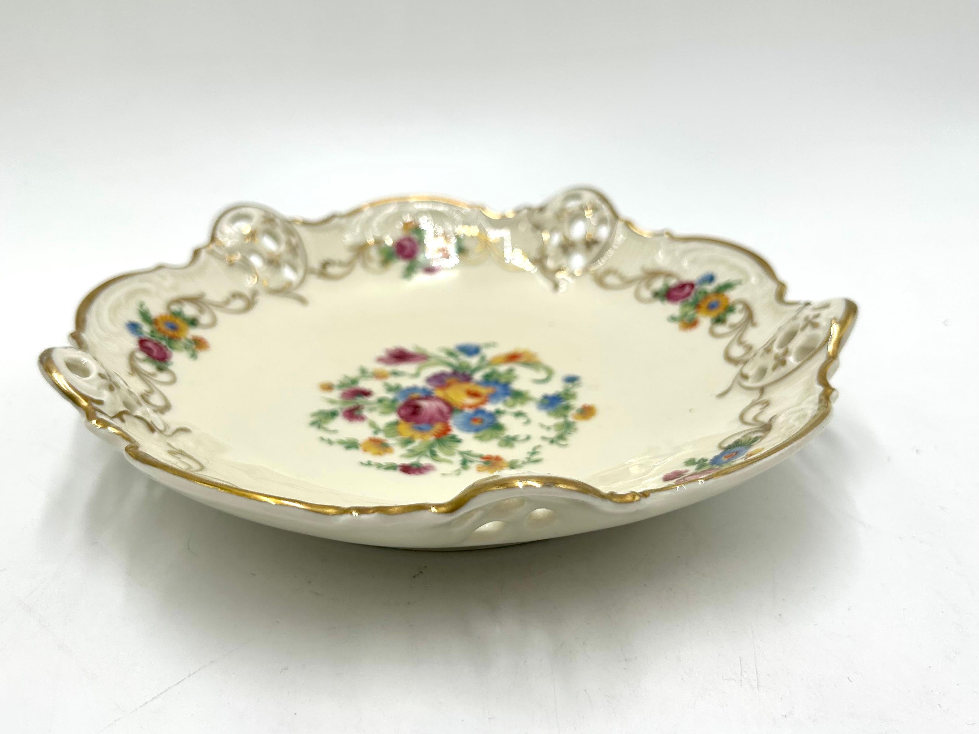 A plate with openwork sides from the Moliere series by the renowned German Rosenthal porcelain factory.

Ecru porcelain decorated with gilding on the edges and a floral bouquet motif.

Signed with the mark of the manufacturer from the years