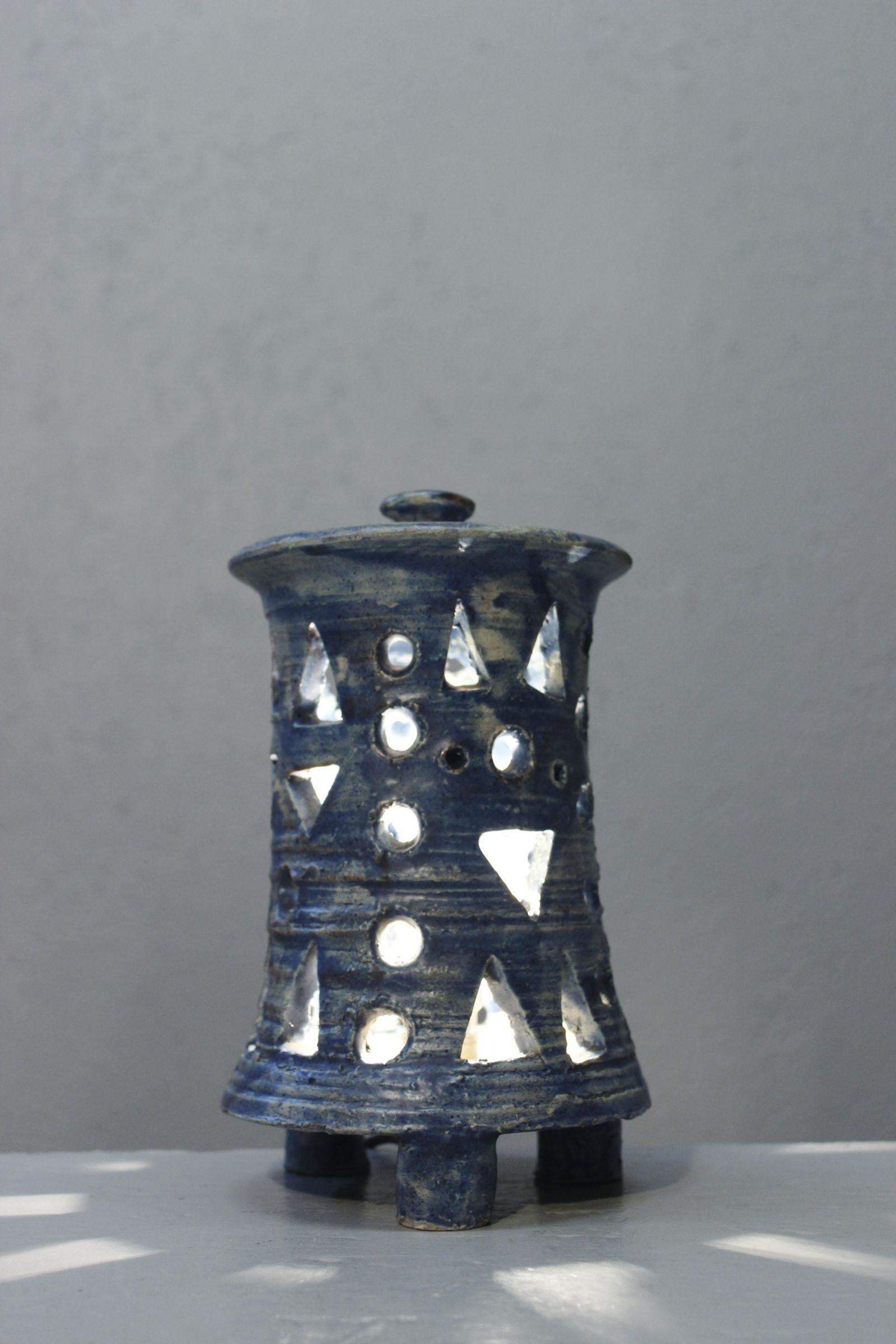 Bellissima lampada in terracotta traforata con smalto blu sfumato, che forma una lanterna con coperchio. 

Firma da decifrare, produzione della metà del XX secolo, nel gusto di Robert Robert e Chantal, Georges Pelletier, Accolay...

Buone