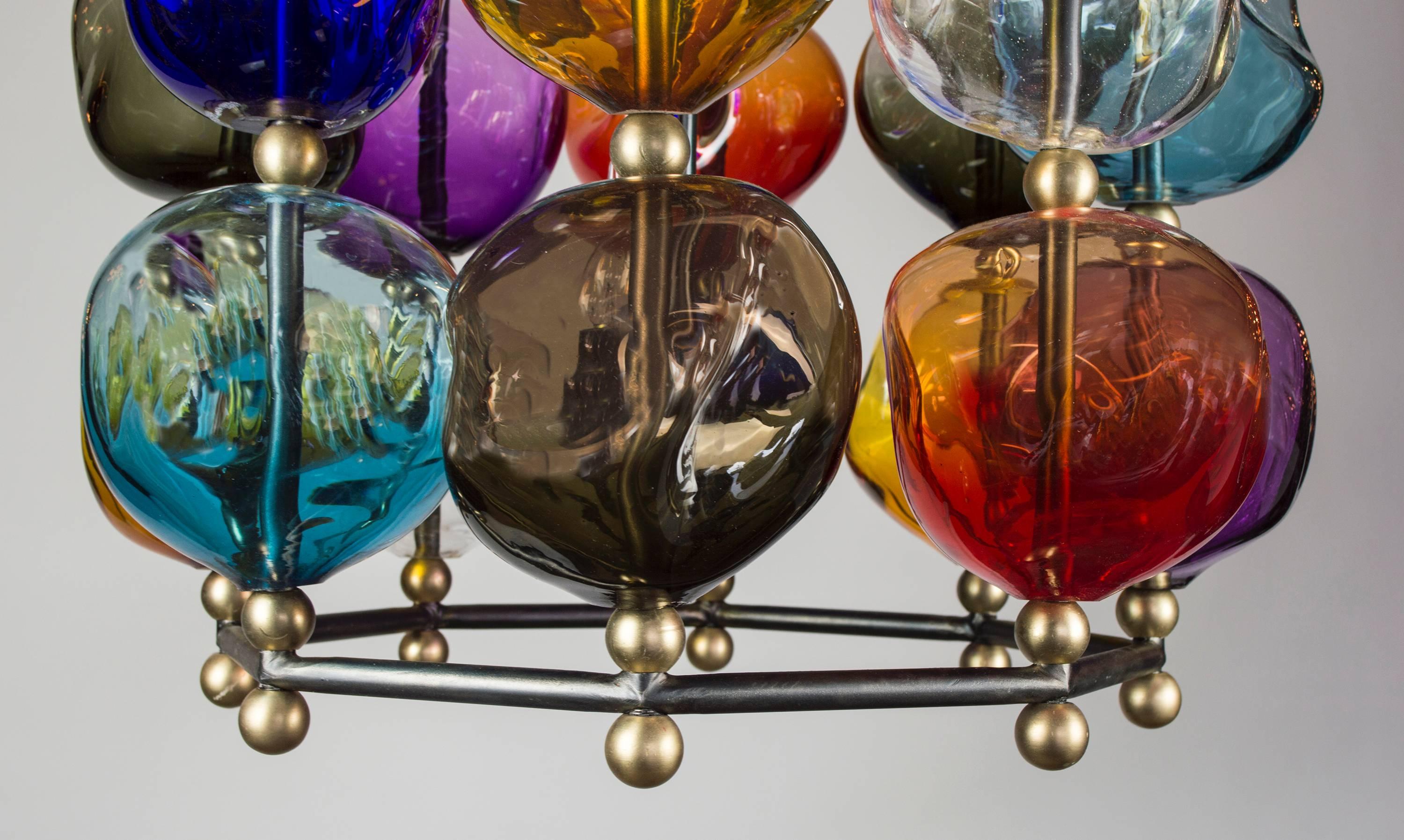 A fresh expression of the Classic lantern created to accentuate the shimmering light, which reflects in the many contours of the glass. The hand blown glass orbs with their asymmetrical shapes are assembled on an octagonal gunmetal steel frame