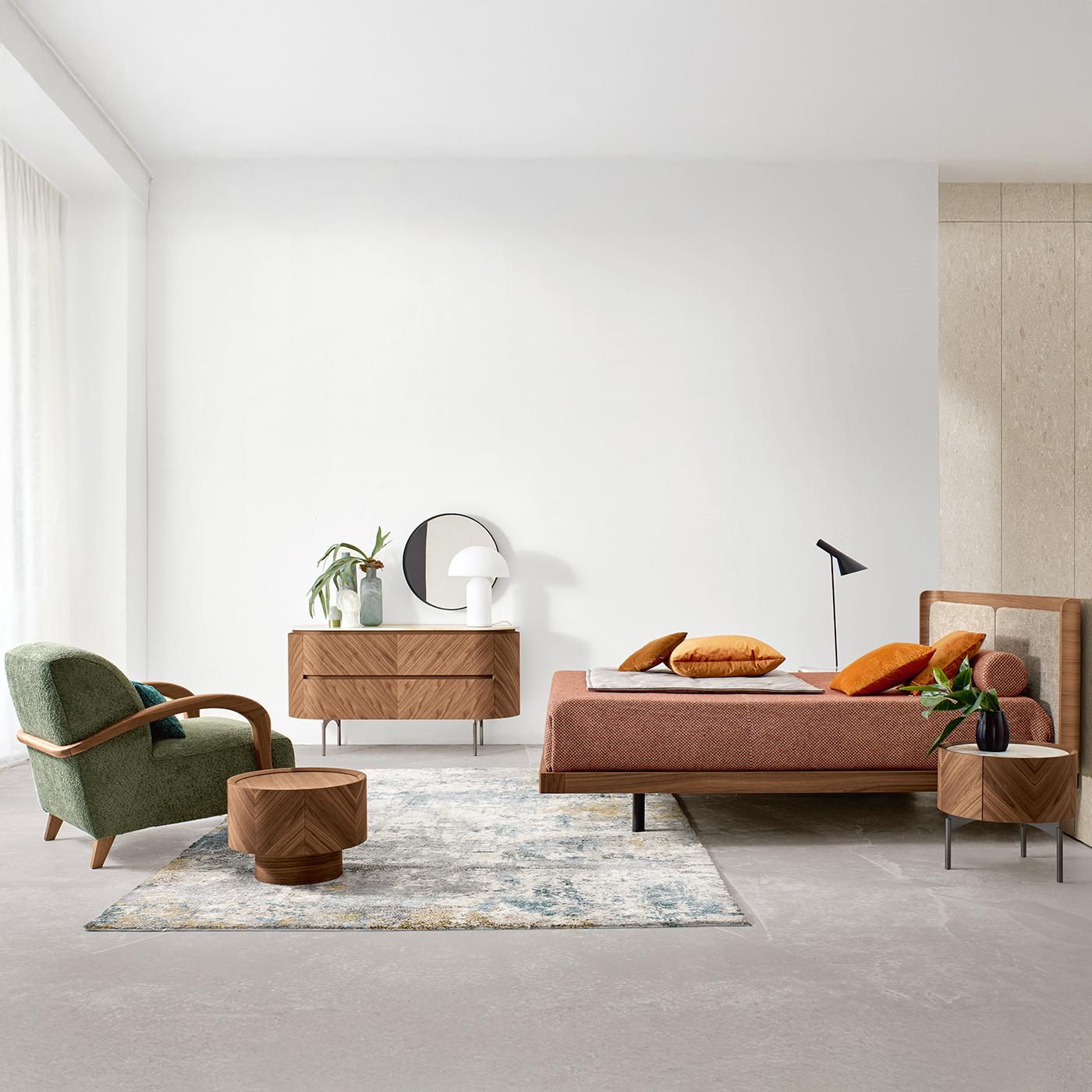 Versatile per diversi ambienti, questo comodino armonizza il caldo noce Avana con un audace piano in ceramica Calacatta. L'impiallacciatura a spina di pesce esalta la struttura arrotondata, fondendo precisione geometrica e texture organica.