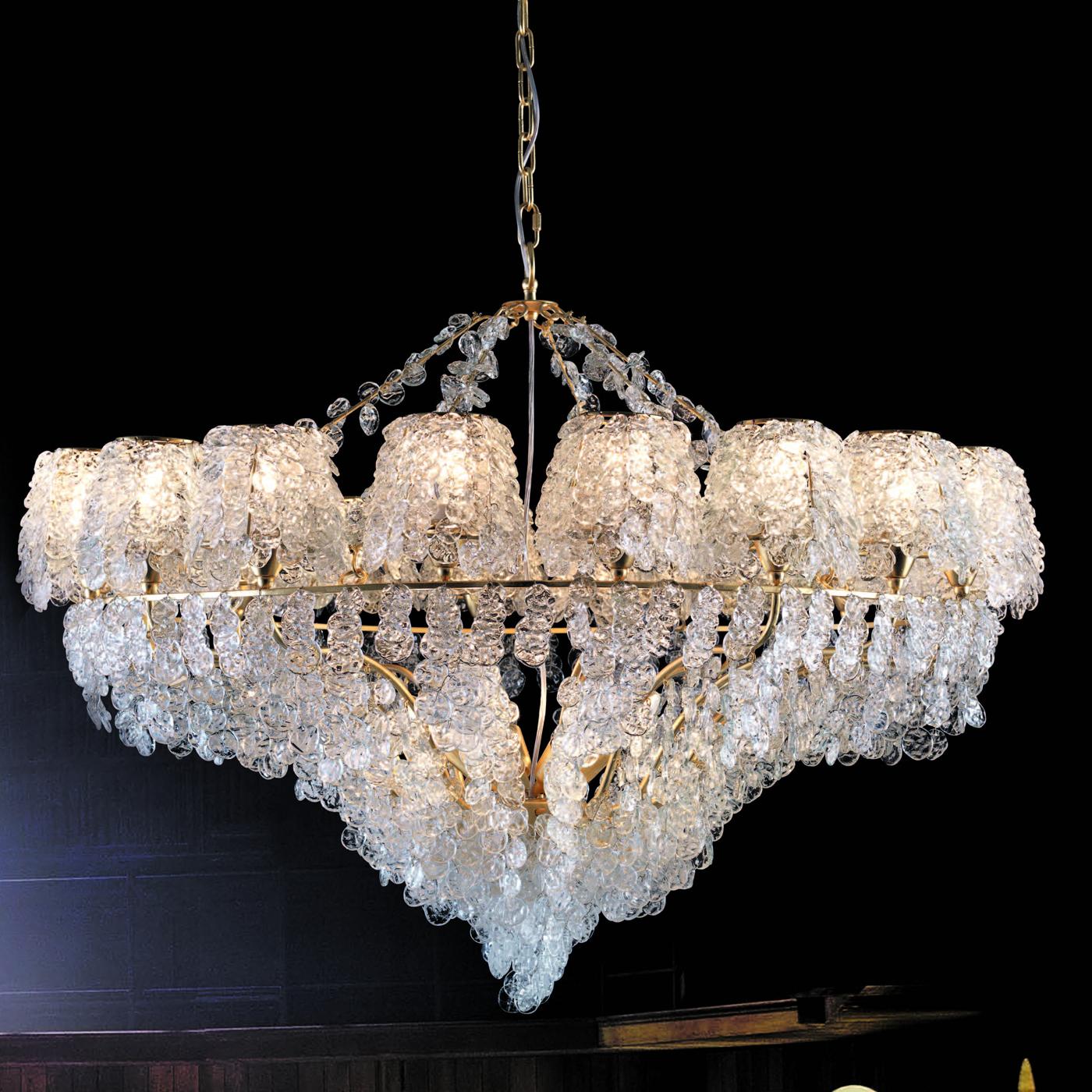 Entirely covered with highly-reflective glass pendants that are meticulously hand-tied by expert artisans, this splendid chandelier comprises a tiered metal frame covered with gold leaf that showcases 18 ES bulbs (G9 max 33W each) distributed on the