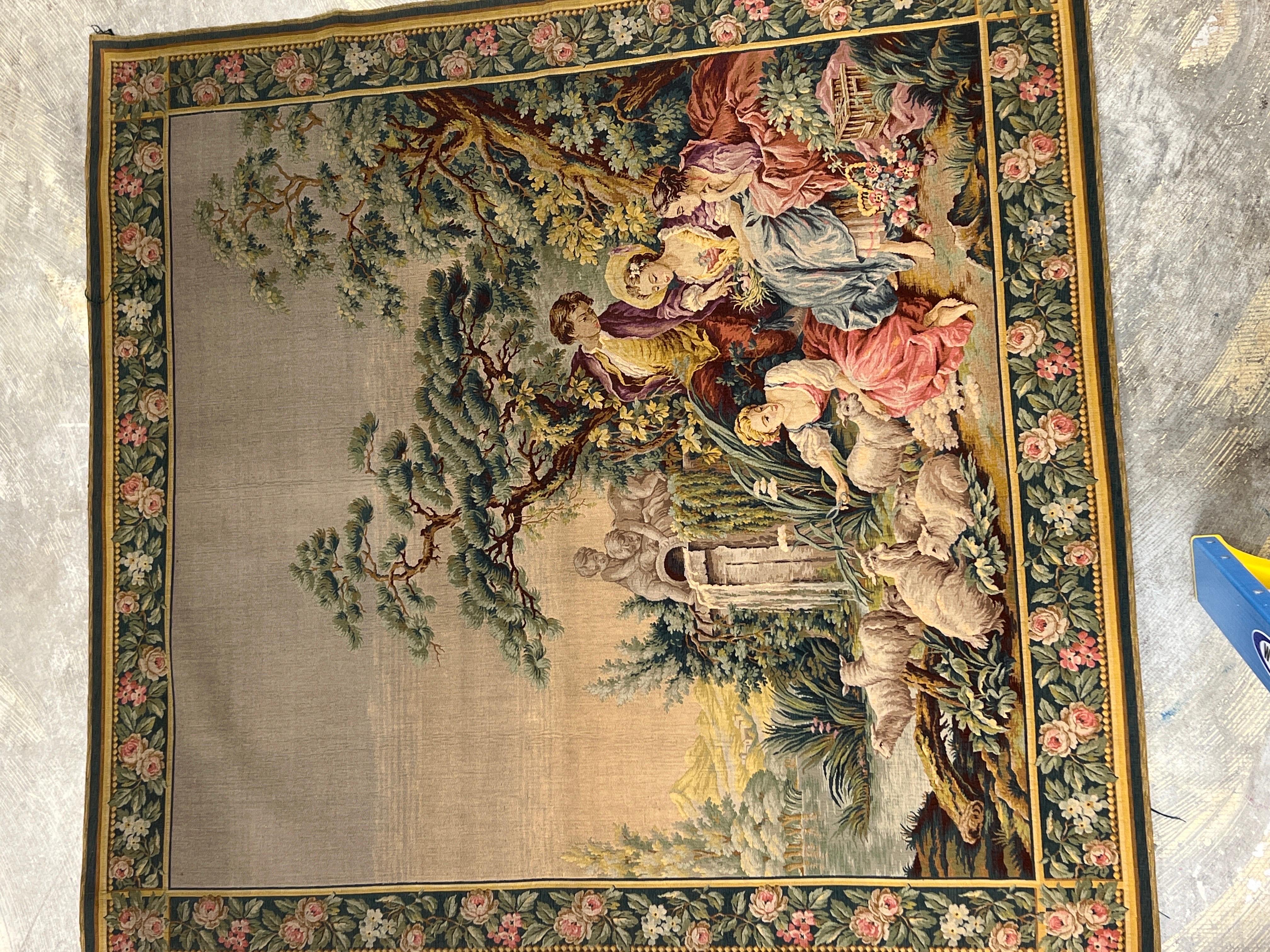 A pair of antique 19th century French hand knotted Aubusson tapestries. Each tapestry is decorated with a floral bordering, romantic scenes to foreground and a family of sheep herders grazing under a capriccio landscape. The left tapestry is