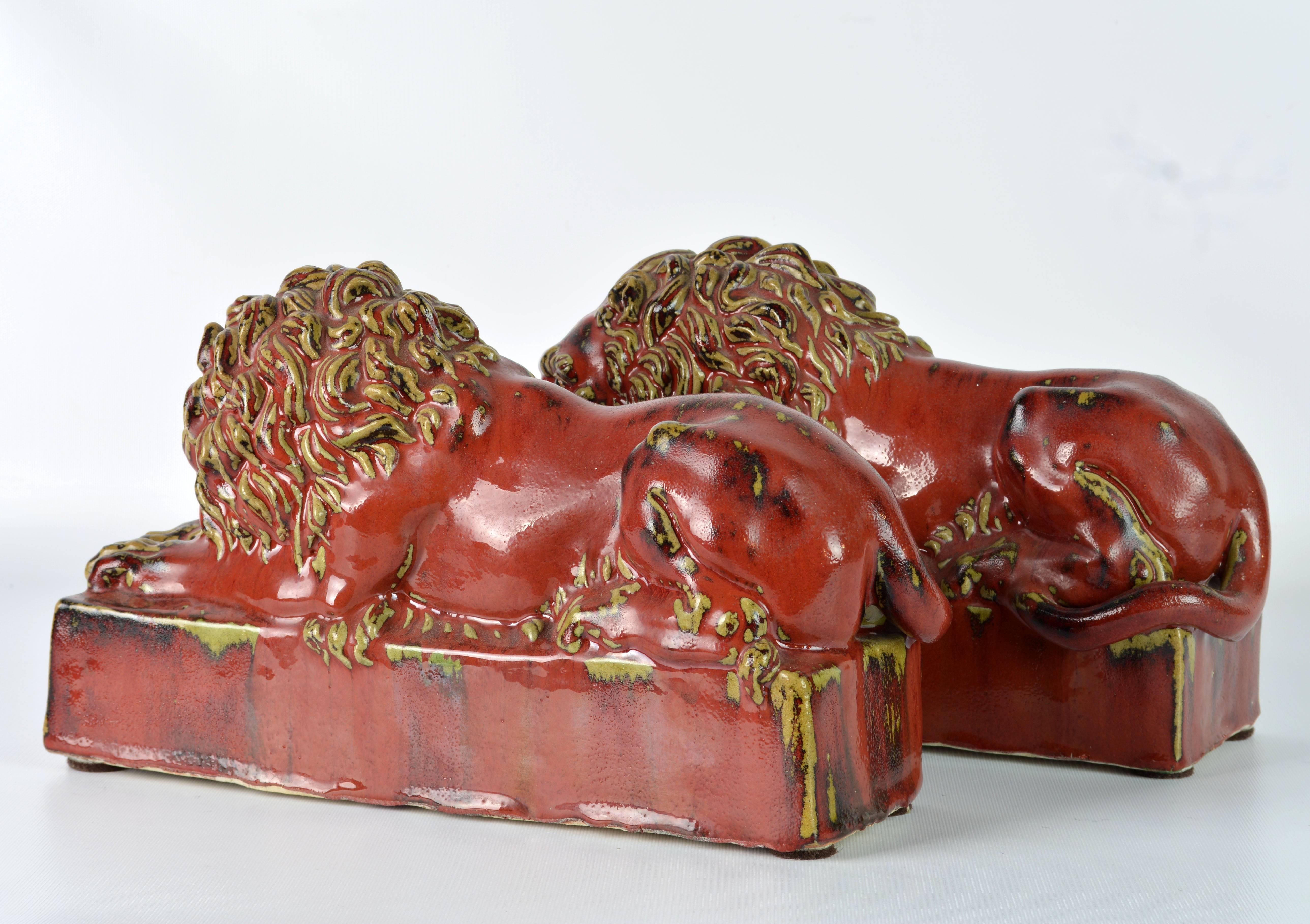 European Opposing Pair of 20th Century Oxblood and Celadon Glazed Ceramic Resting Lions