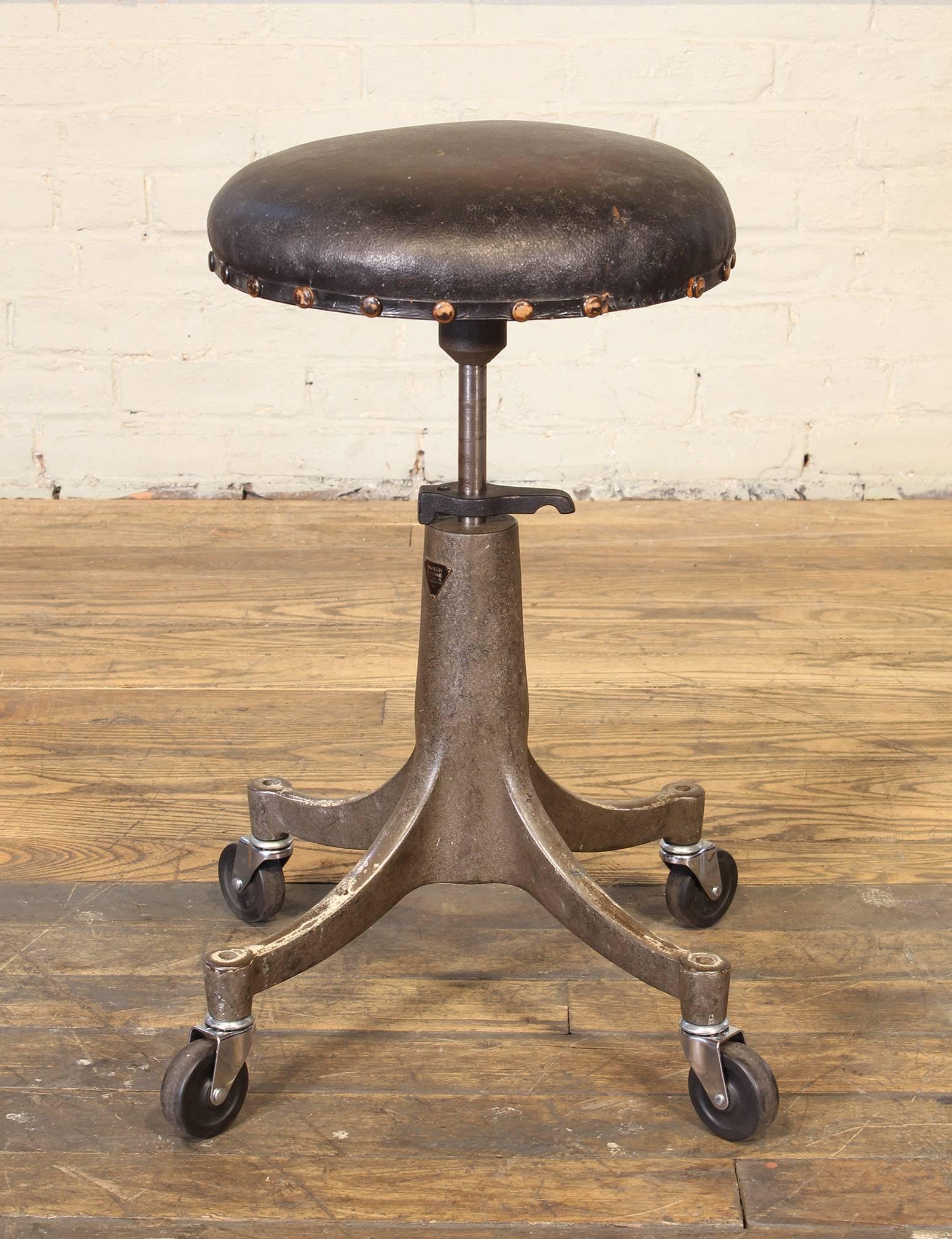 Vintage authentic Bausch & Lomb medical eye doctor's / opticians / optometrists stool. Features four swivel castors, height adjustment lever, brass tacks, rubber wheels, worn leather seat, painted cast iron base and Bausch & Lomb badge. Reads