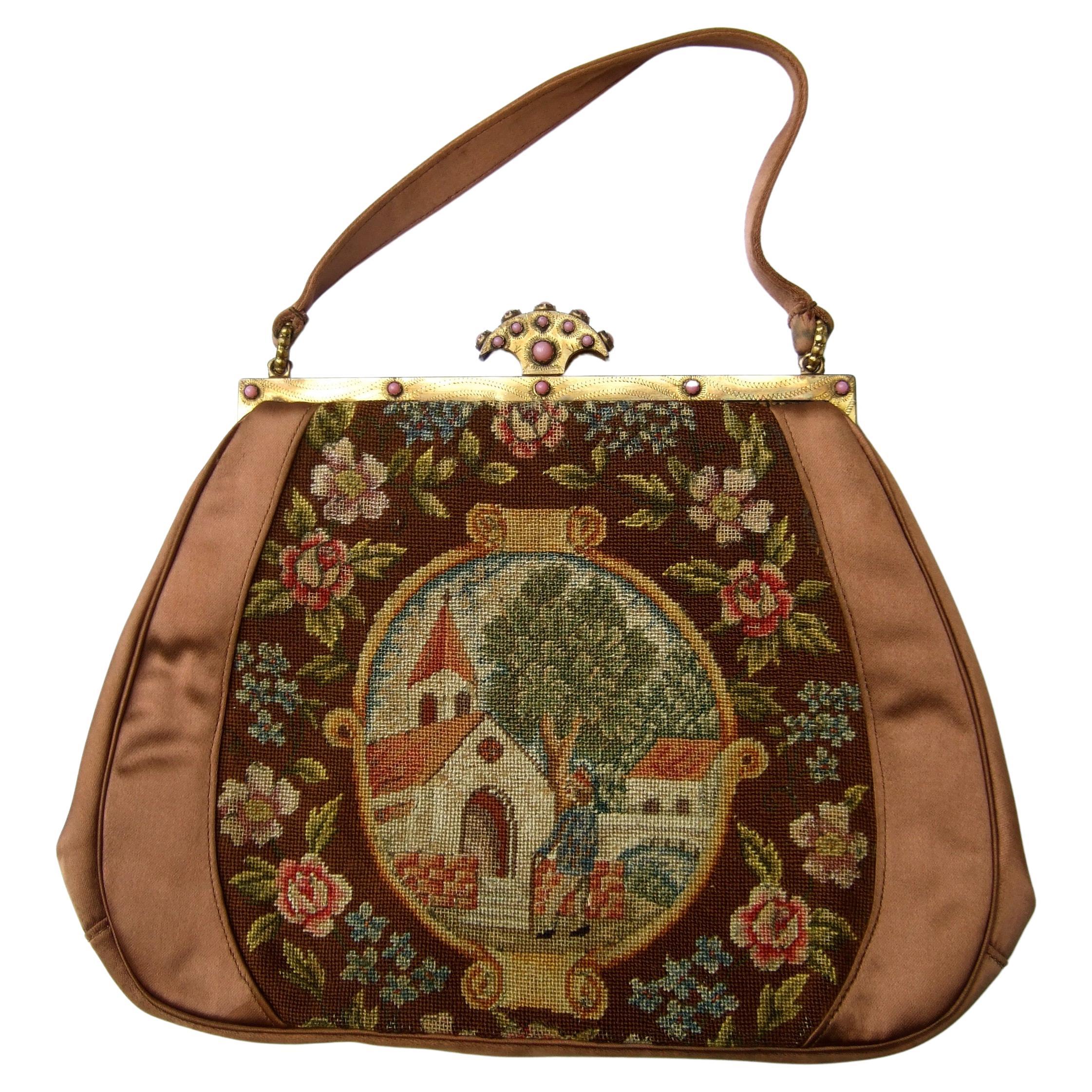 Opulent French petit point glass jeweled copper satin evening bag c 1950 
The elegant brown satin evening bag is designed with intricate petit point 
floral panels on both exterior sides. One side of the evening bag depicts 
a woman strolling