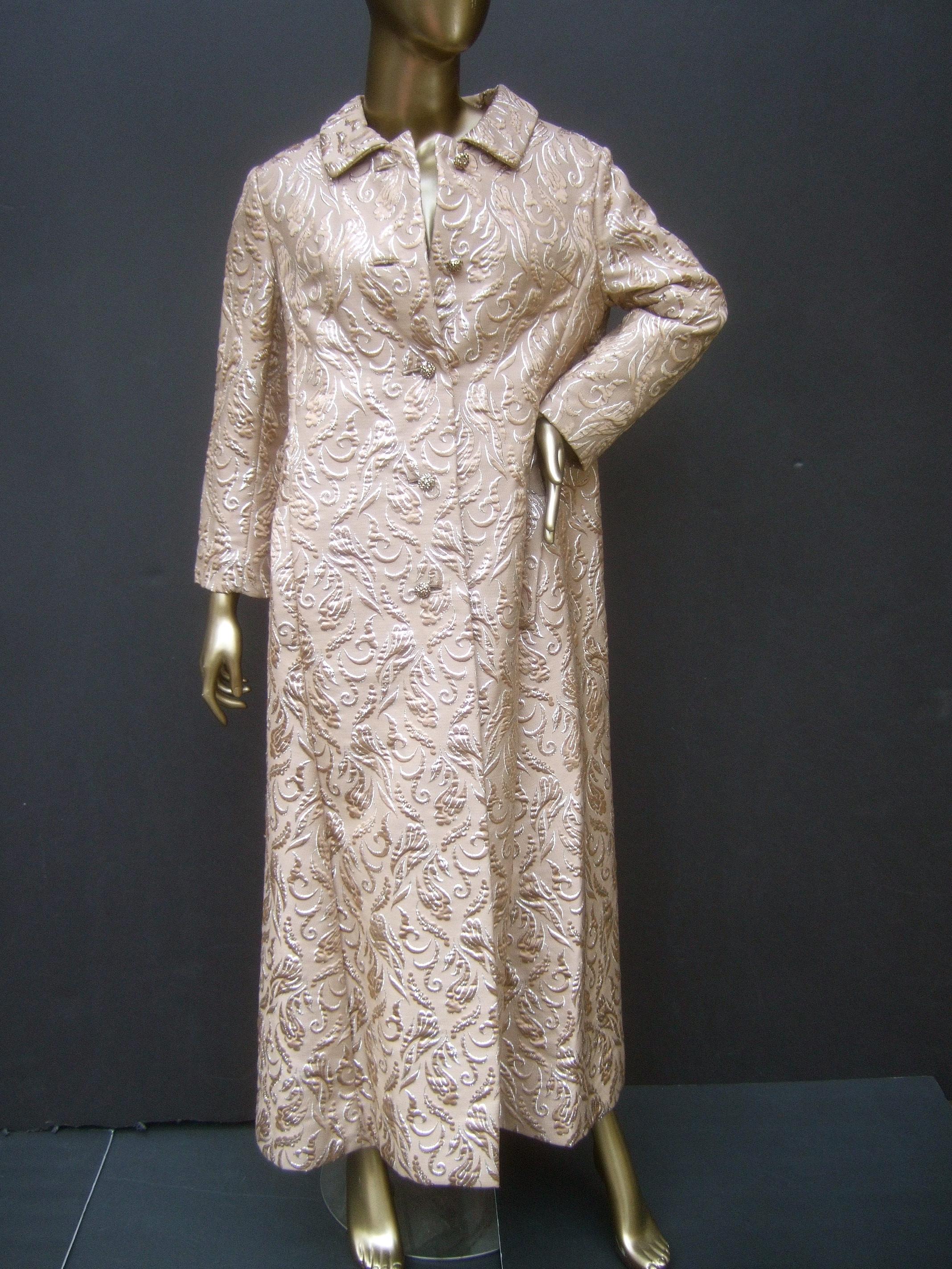 Opulent mocha brown brocade evening coat by Montaldo's c 1960s
The elegant opera coat is designed with thick structured brocade panels
The luminous mocha brown brocade fabric is illuminated with sinuous 
swirls of silver metallic

Adorned with five